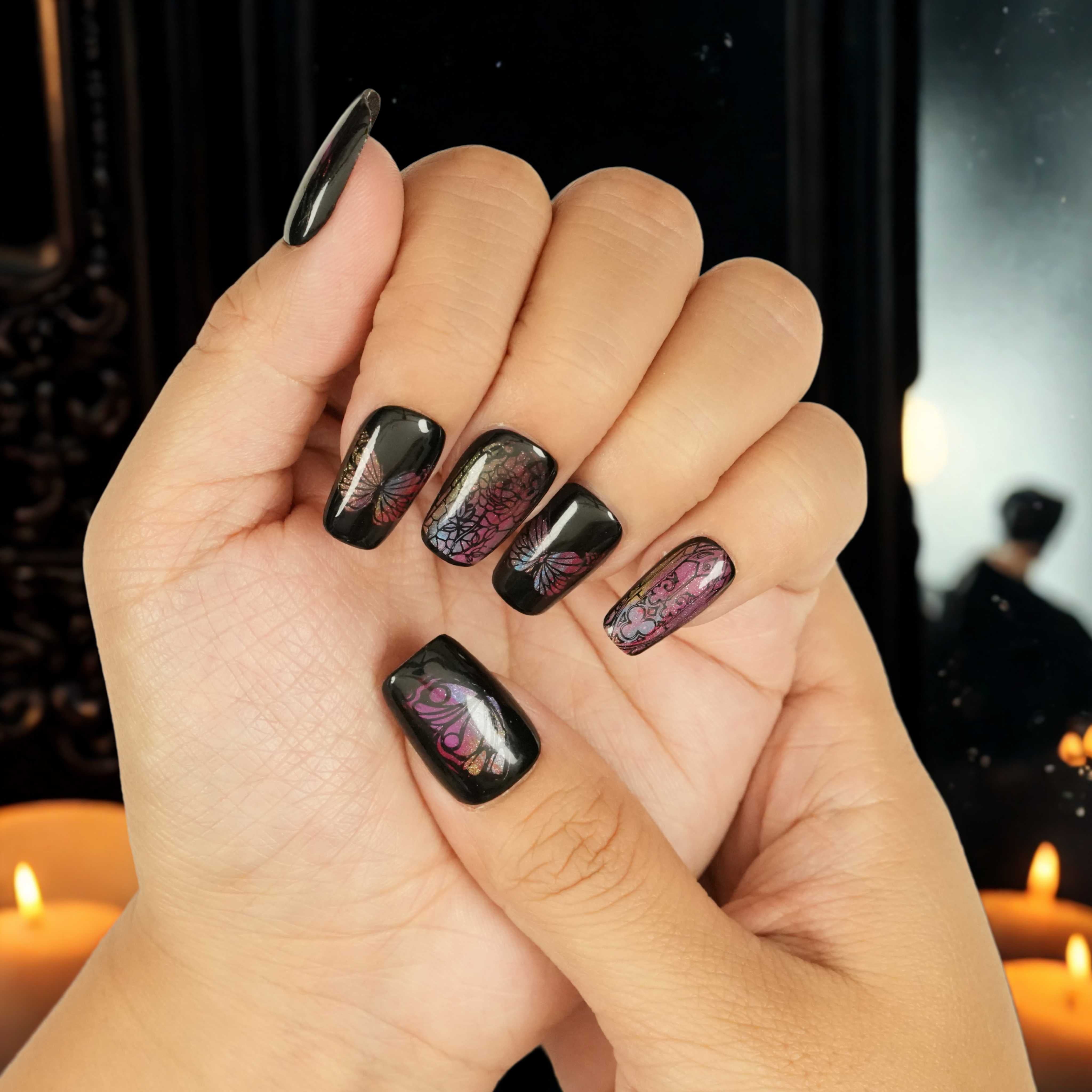 False nails with black glossy finish and detailed butterfly art in iridescent hues, styled for a bold, moody look. Stick on nails Australia