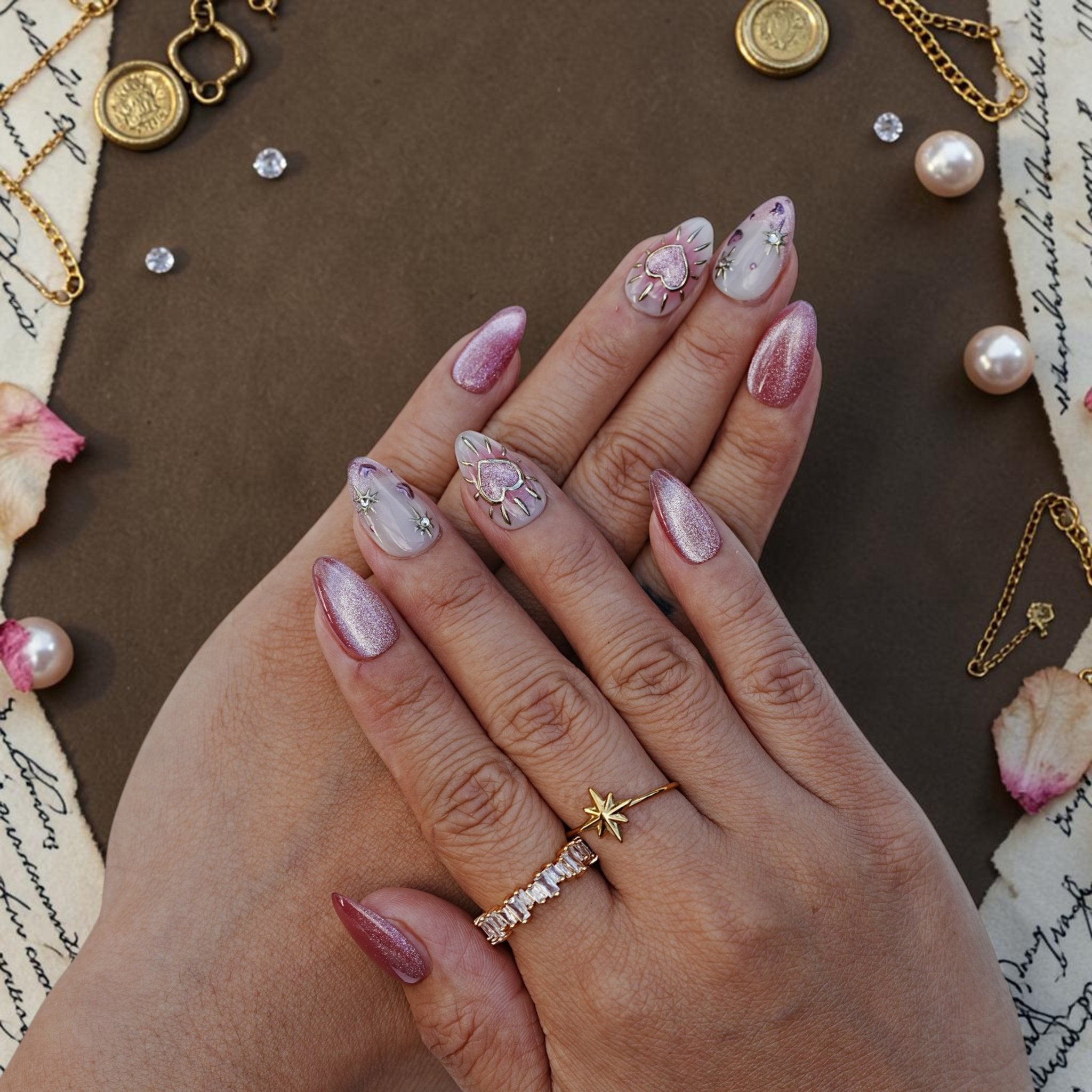 DSC00007 hand wearing heart press on nails with gold heart charms and pink cat eye shimmer