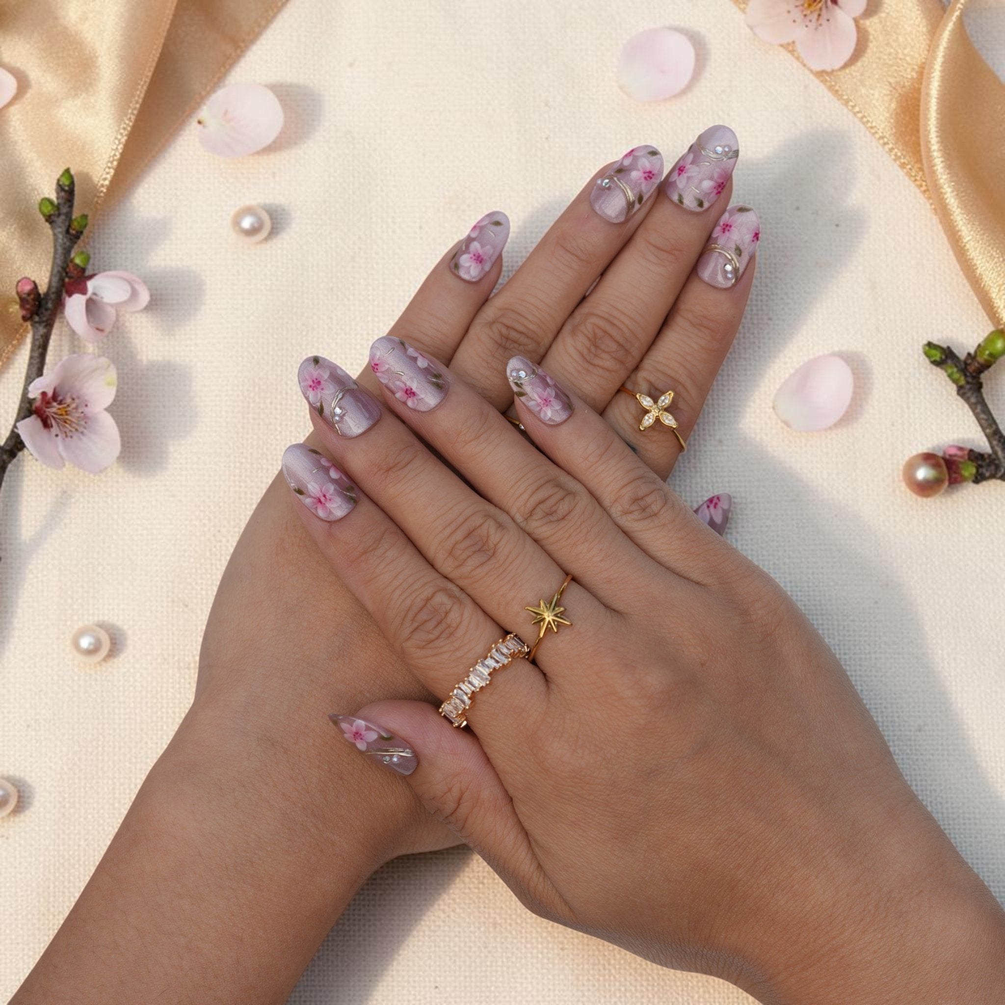 DSC00012 hands wearing sakura press on nails with pink blossoms and gold accents