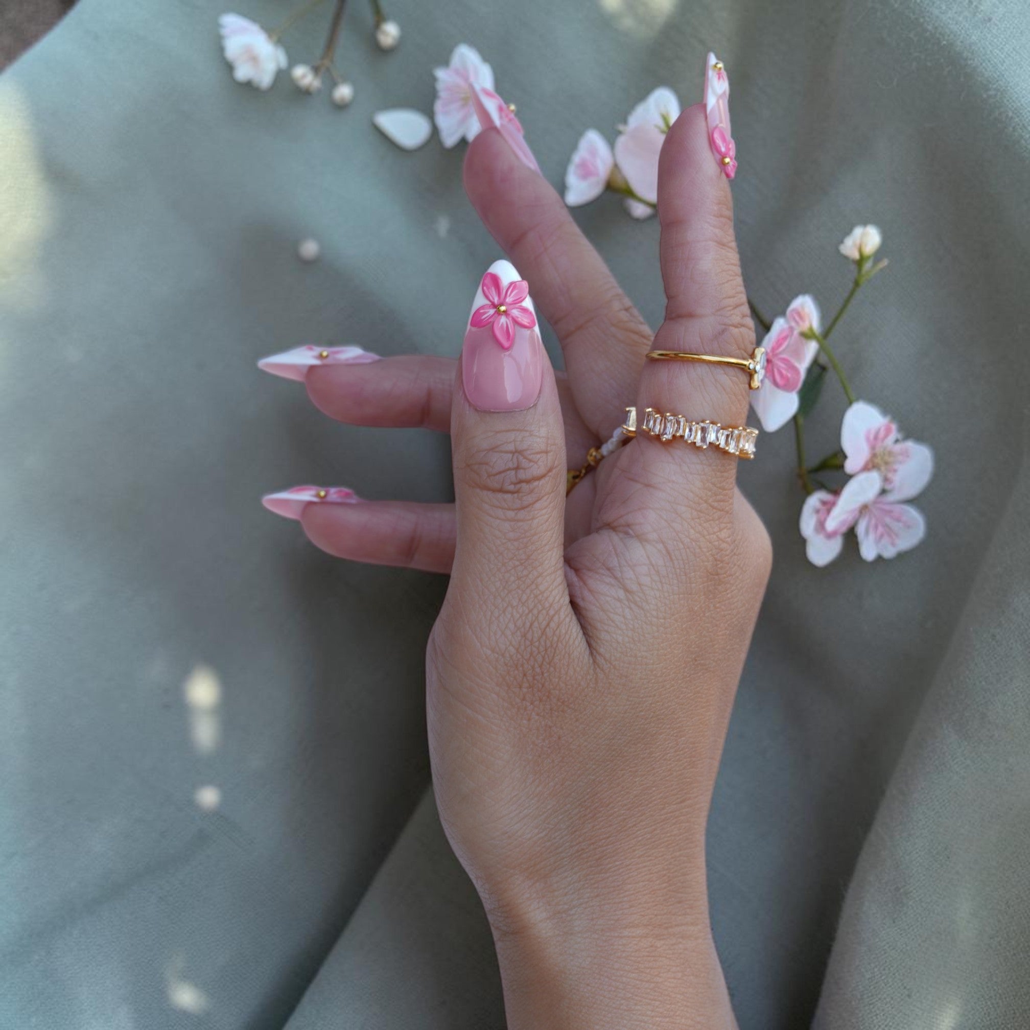 Long almond press on nails with pink blooms, white tips and gold accents