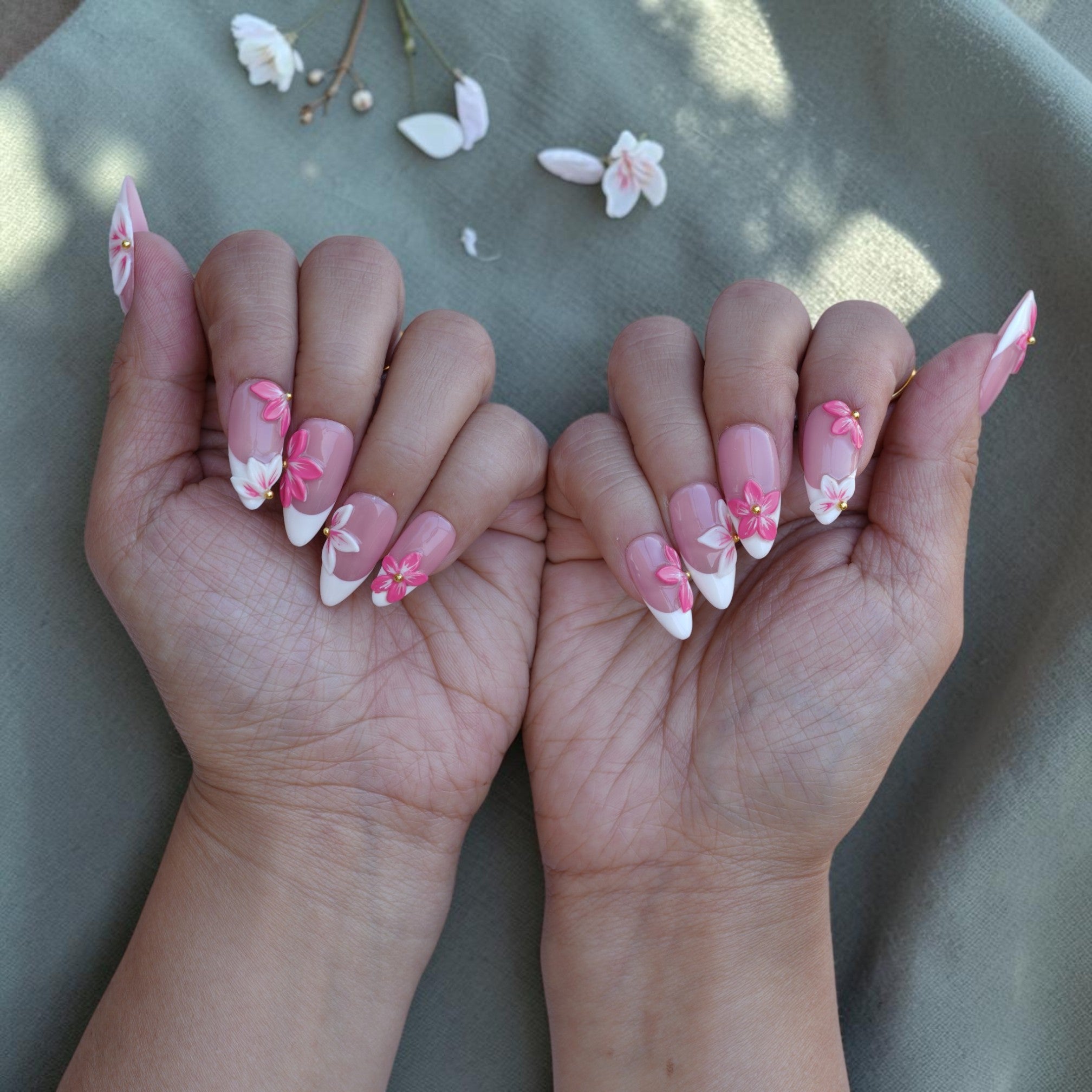 Both hands wearing Sakura Blush 3D flower press on nails with French tips