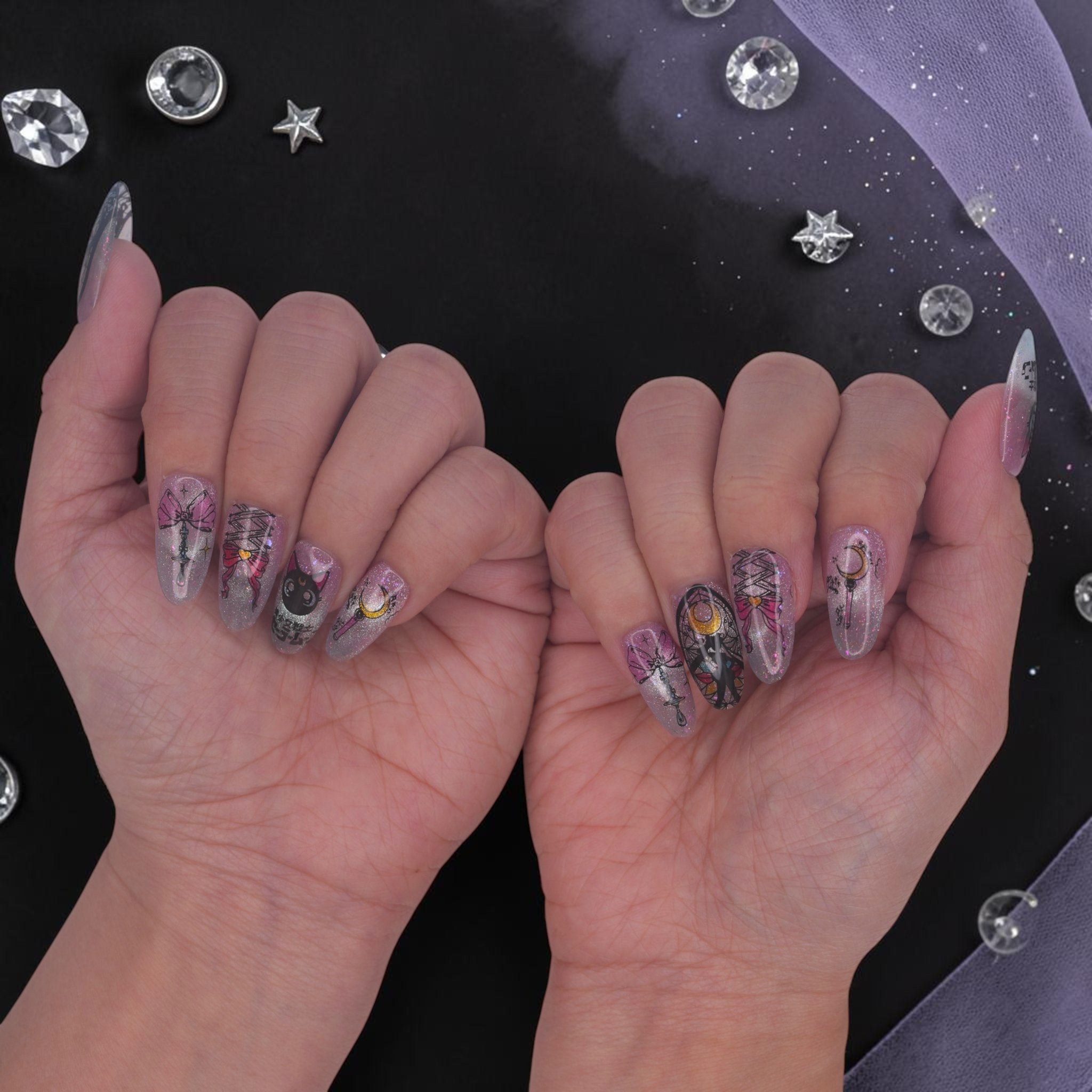 DSC00018 two hands showing celestial anime press on nails with a black cat, moon wand and bows