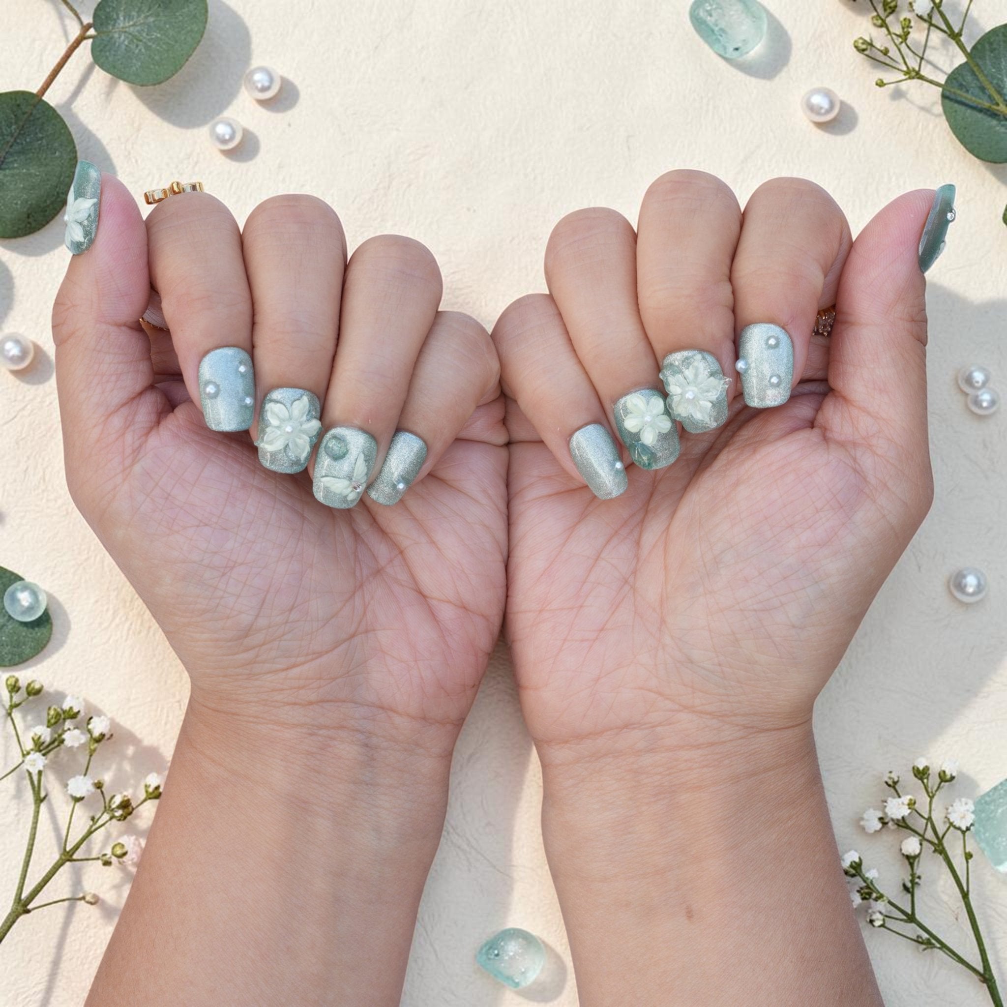 DSC00030 pair of hands showing sage green press on nails with flowers and pearls