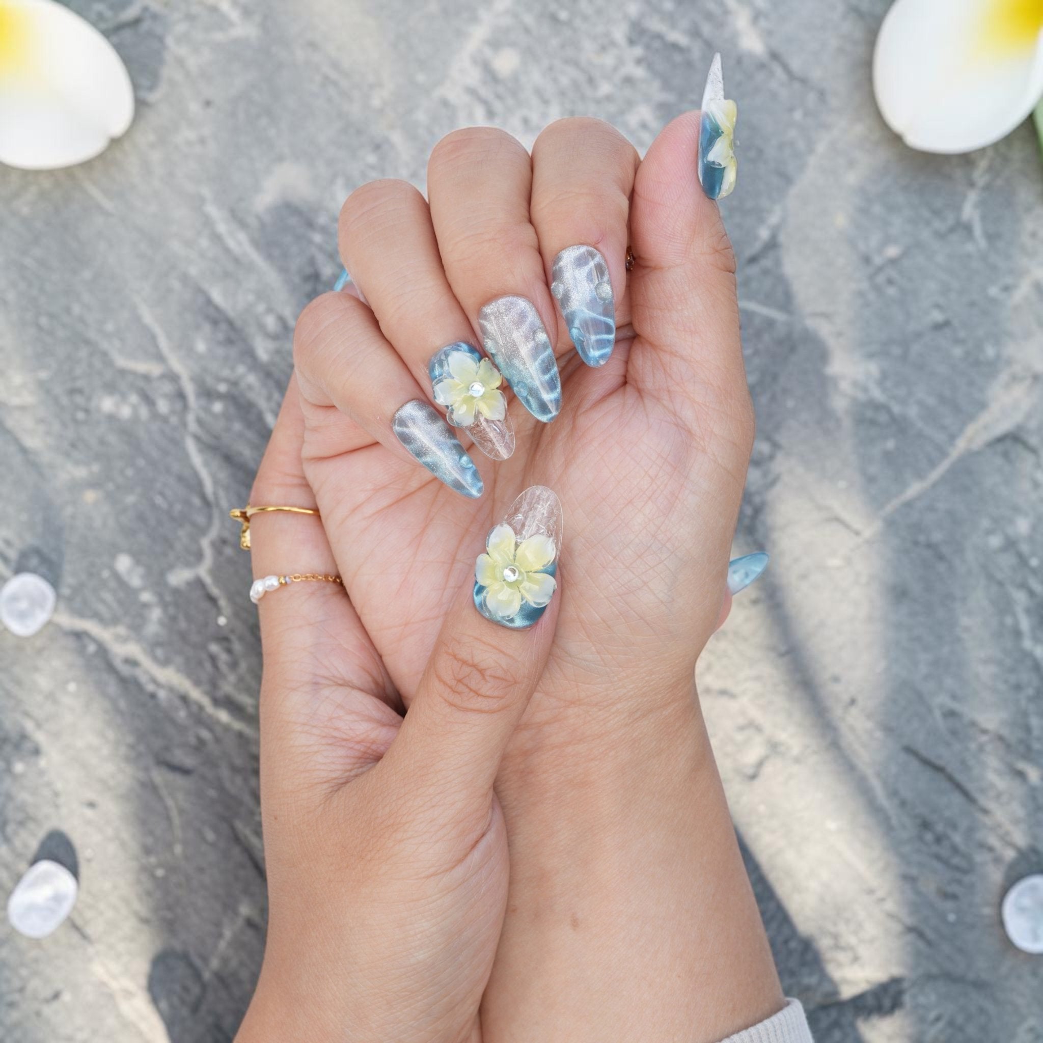 DSC00037 blue and white frangipani press on nails held up in the light