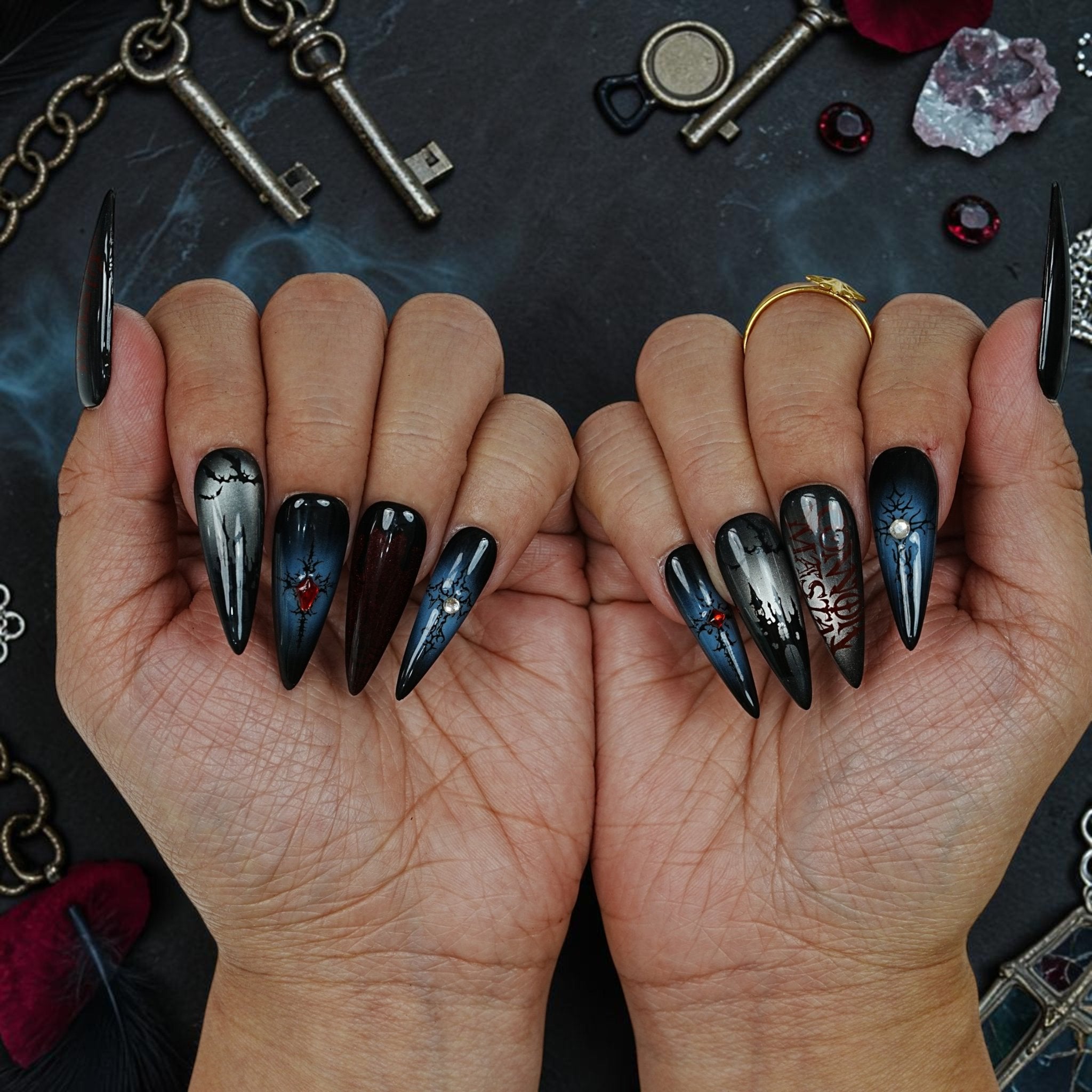 DSC00046 two hands showing black and navy vampire press on nails with cracked gothic design