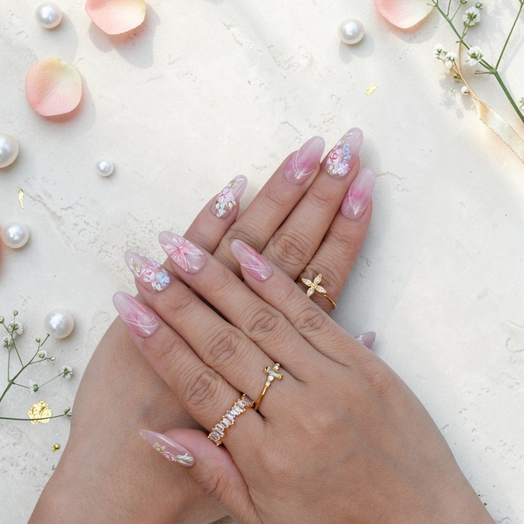 Soft watercolour press on nails worn on hand with pink roses and cat eye shimmer