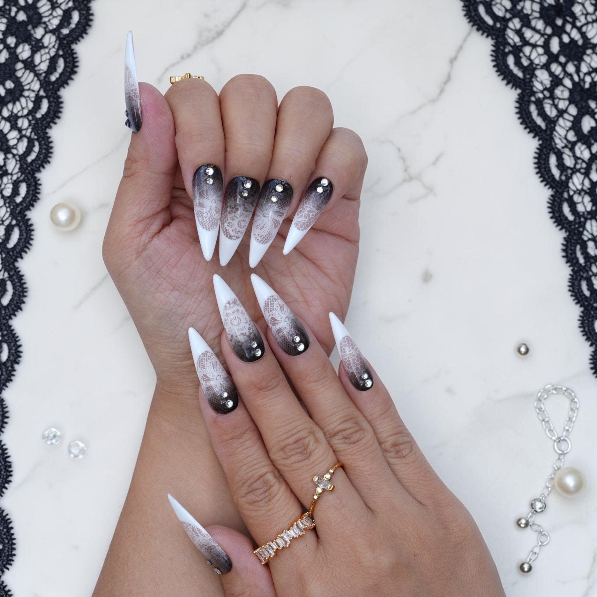 Gothic lace press on nails worn on hand with smoky black ombre, white lace and crystals