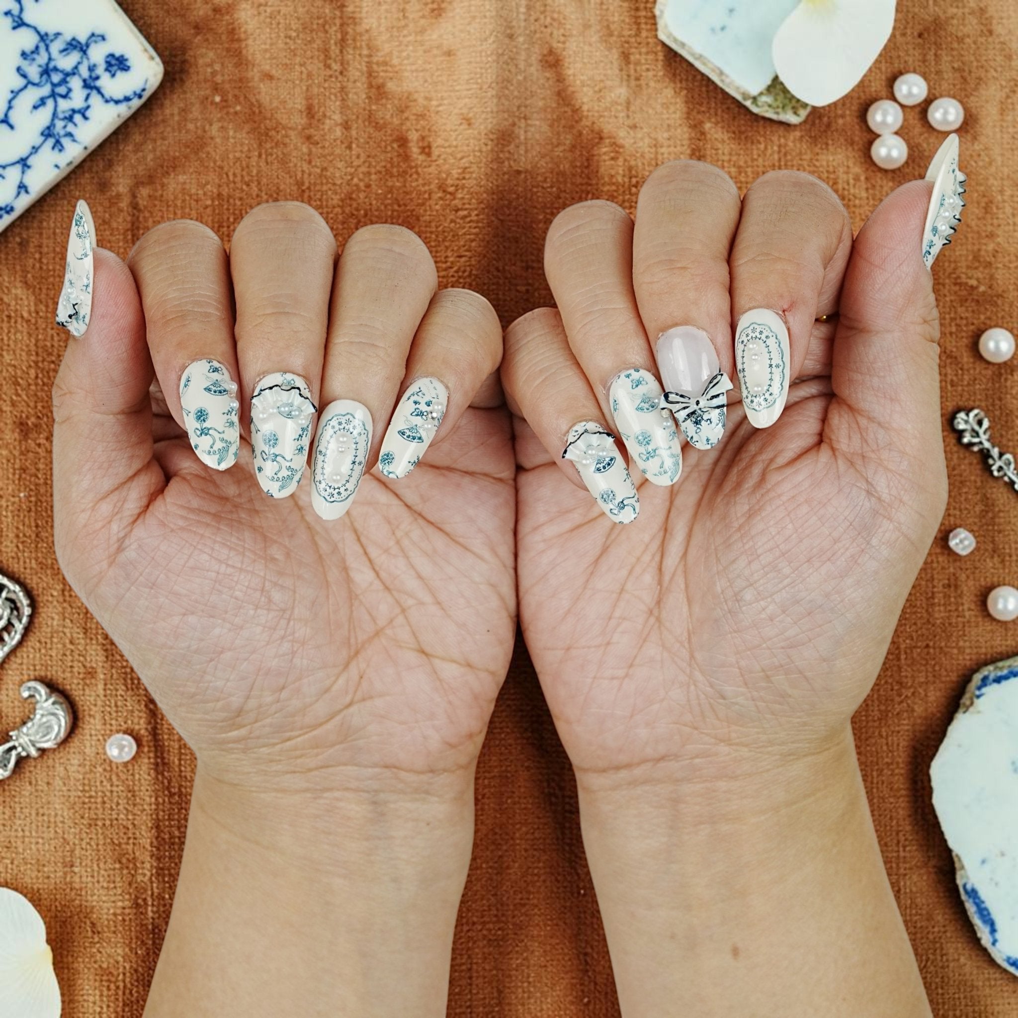 DSC00100 two hands showing blue and white porcelain press on nails with pearls and bows