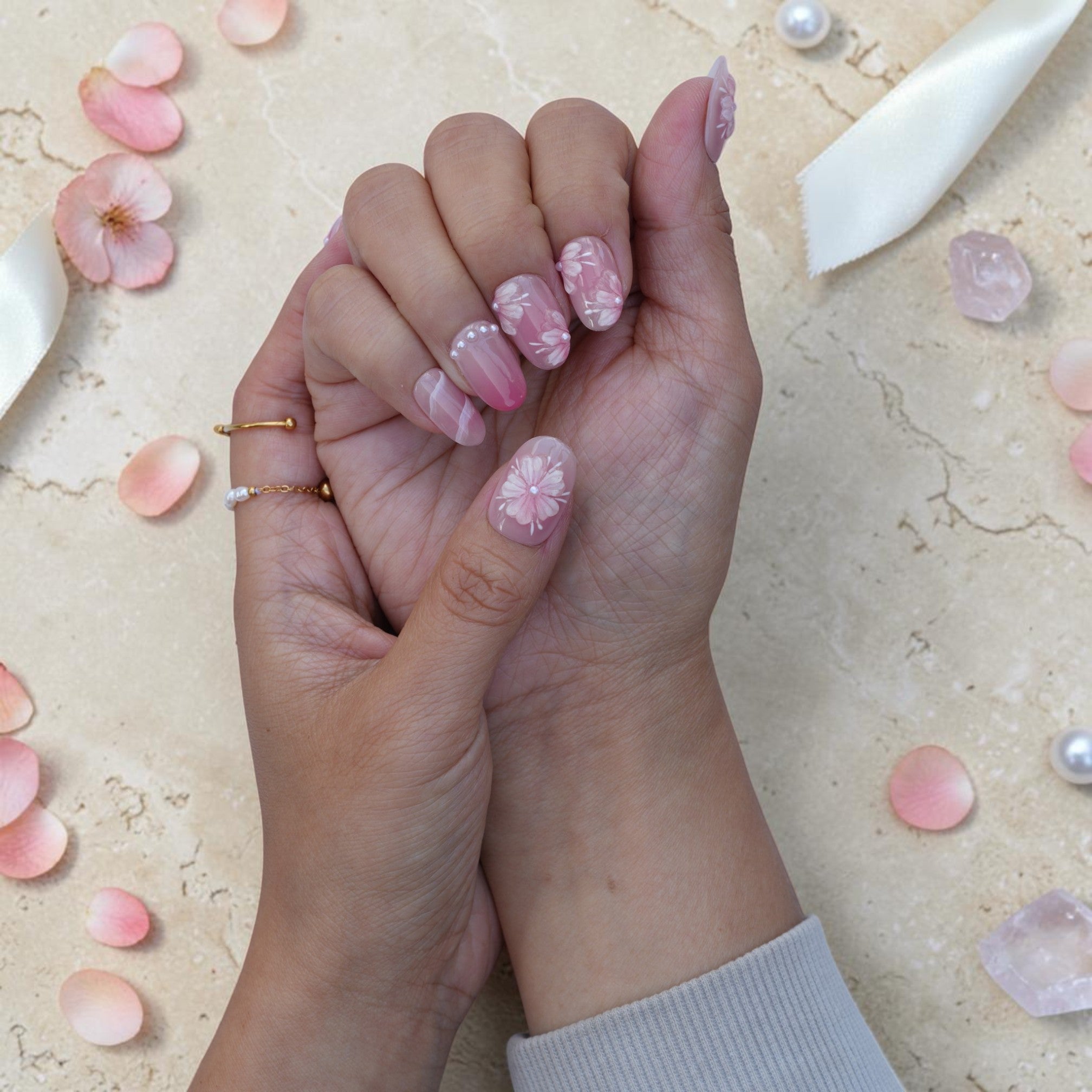 Hanami Bloom press on nails styled on hand with soft pink florals and pearls