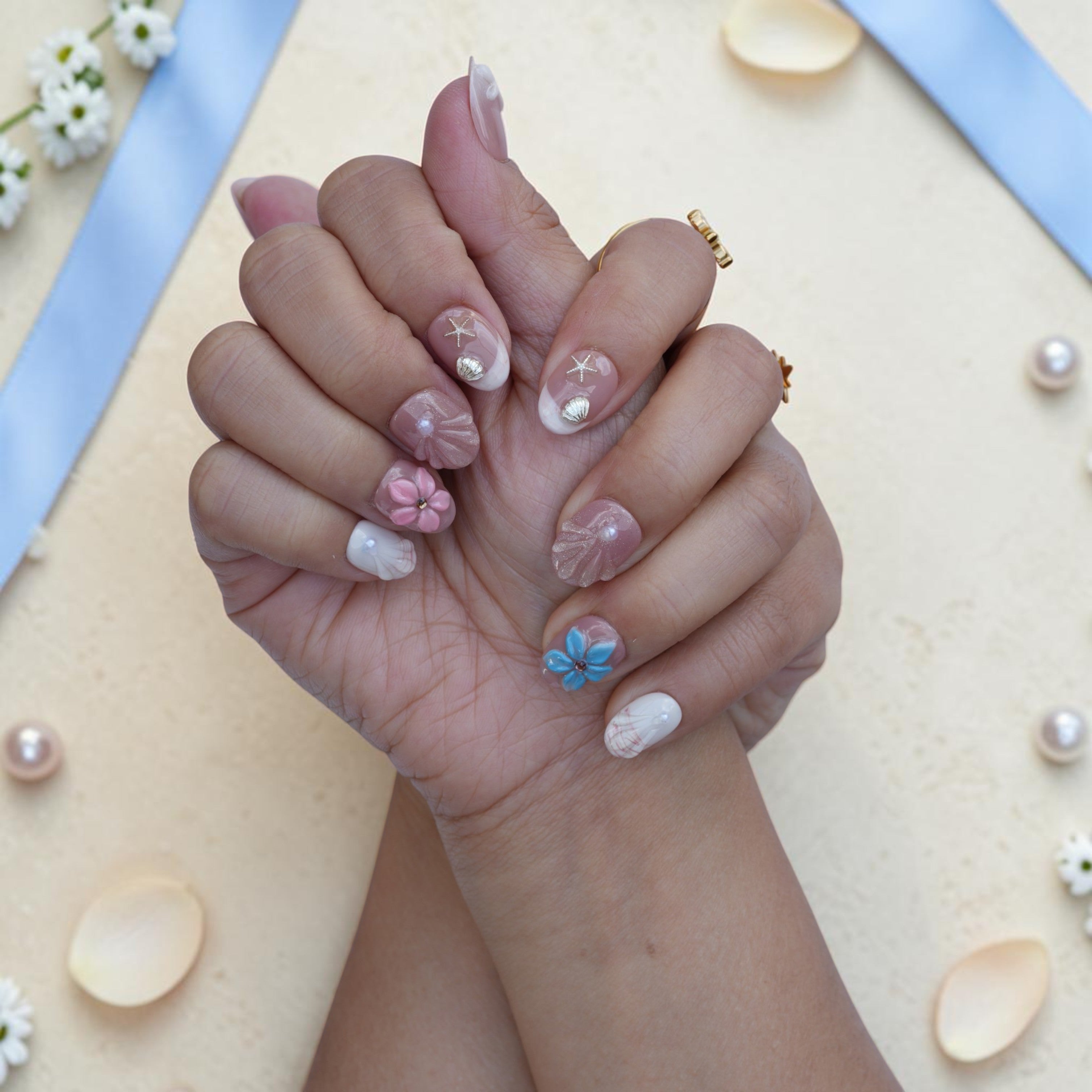 Handmade beach press on nails close up with seashells, starfish and 3D flowers