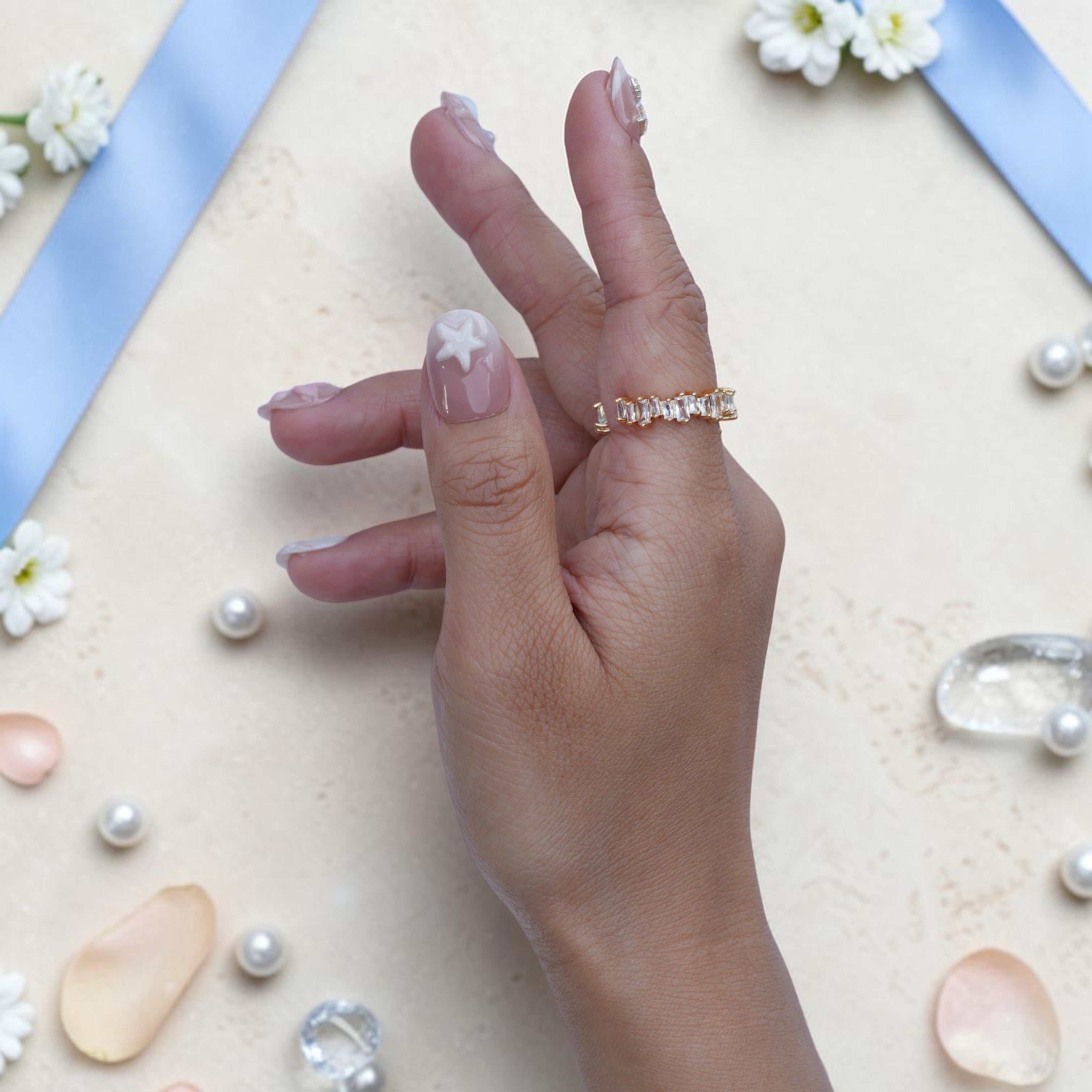 White starfish accent nails in a pink and pearl coastal set