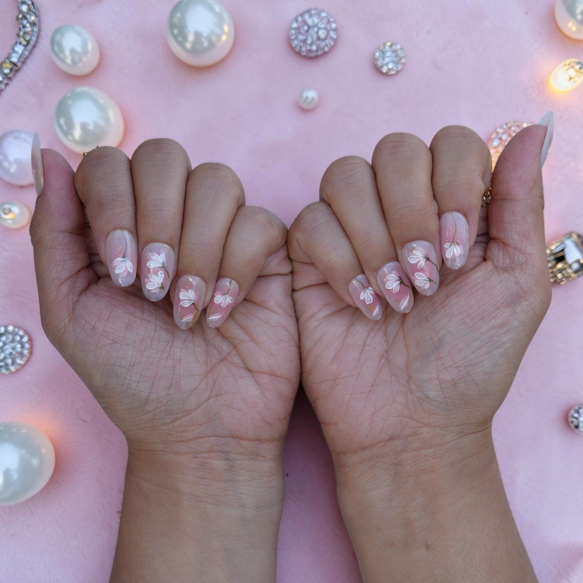 Both hands wearing Magnolia Mist bridal press on nails with delicate white florals