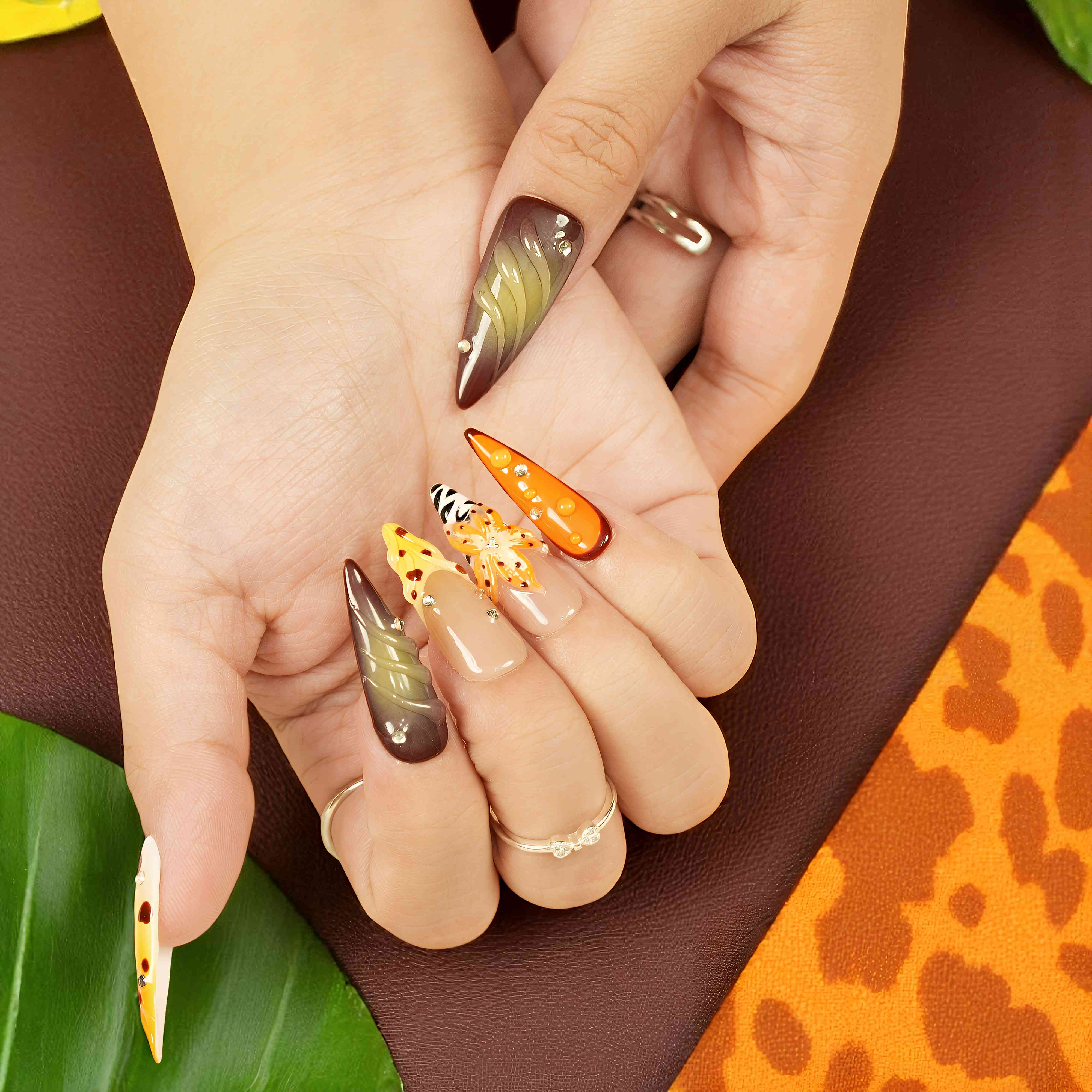 zebra stripe nail design with orange flower and leopard tones