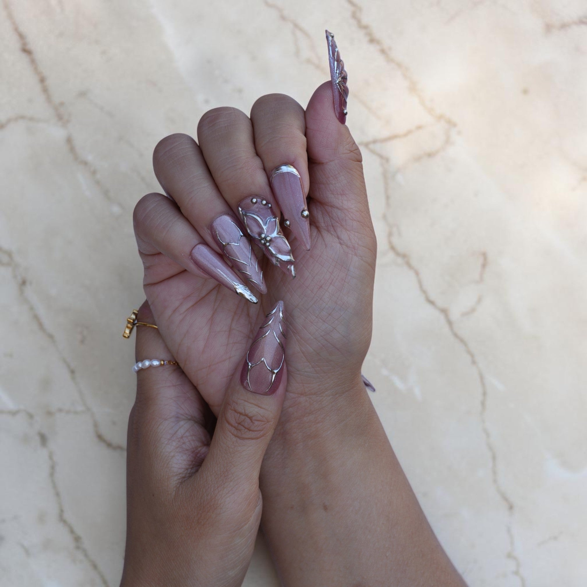 Ethereal mauve stiletto nails with silver chrome detailing and caviar beads