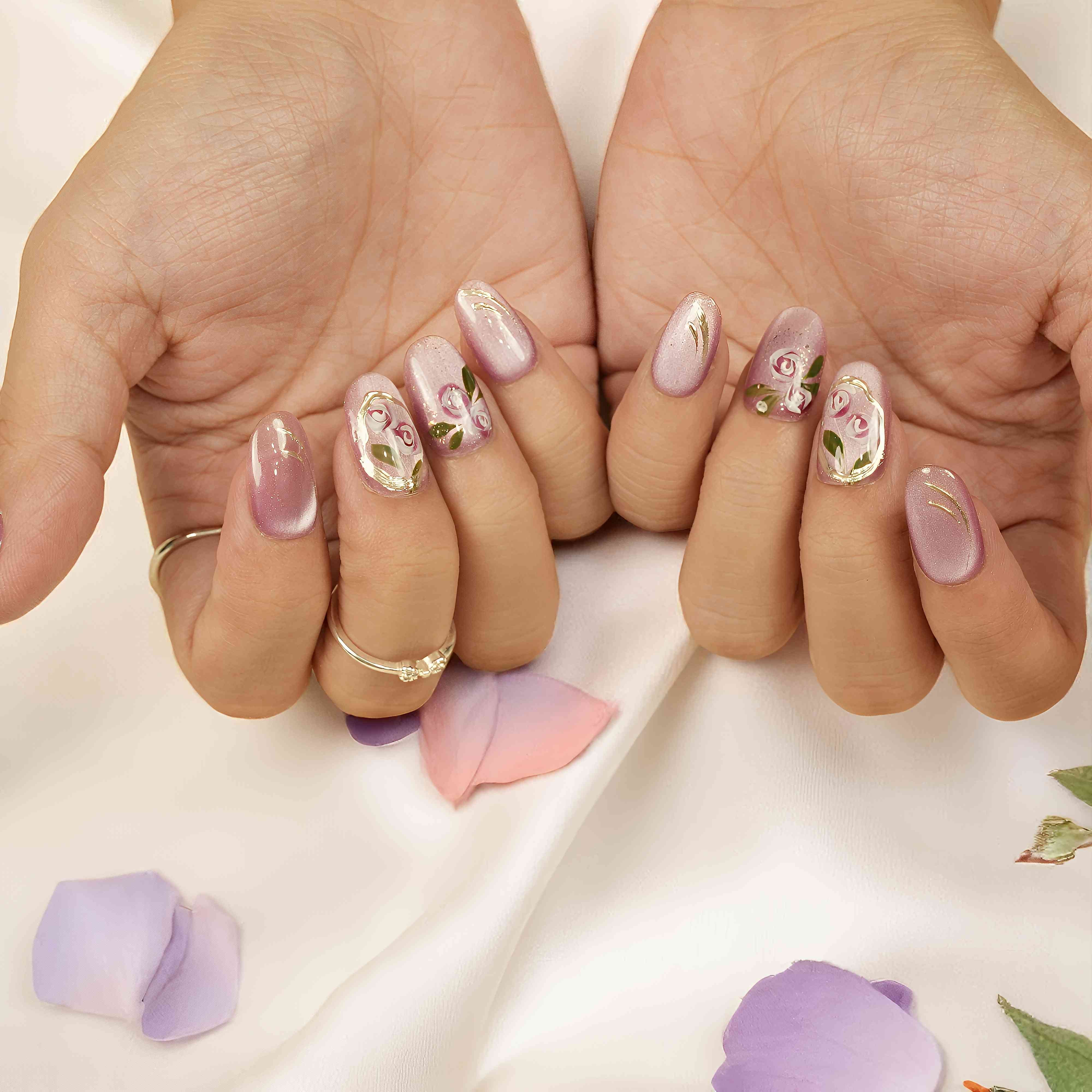 Pink-lilac floral press on nails with painted roses and cat’s eye finish – elegant short fake nails