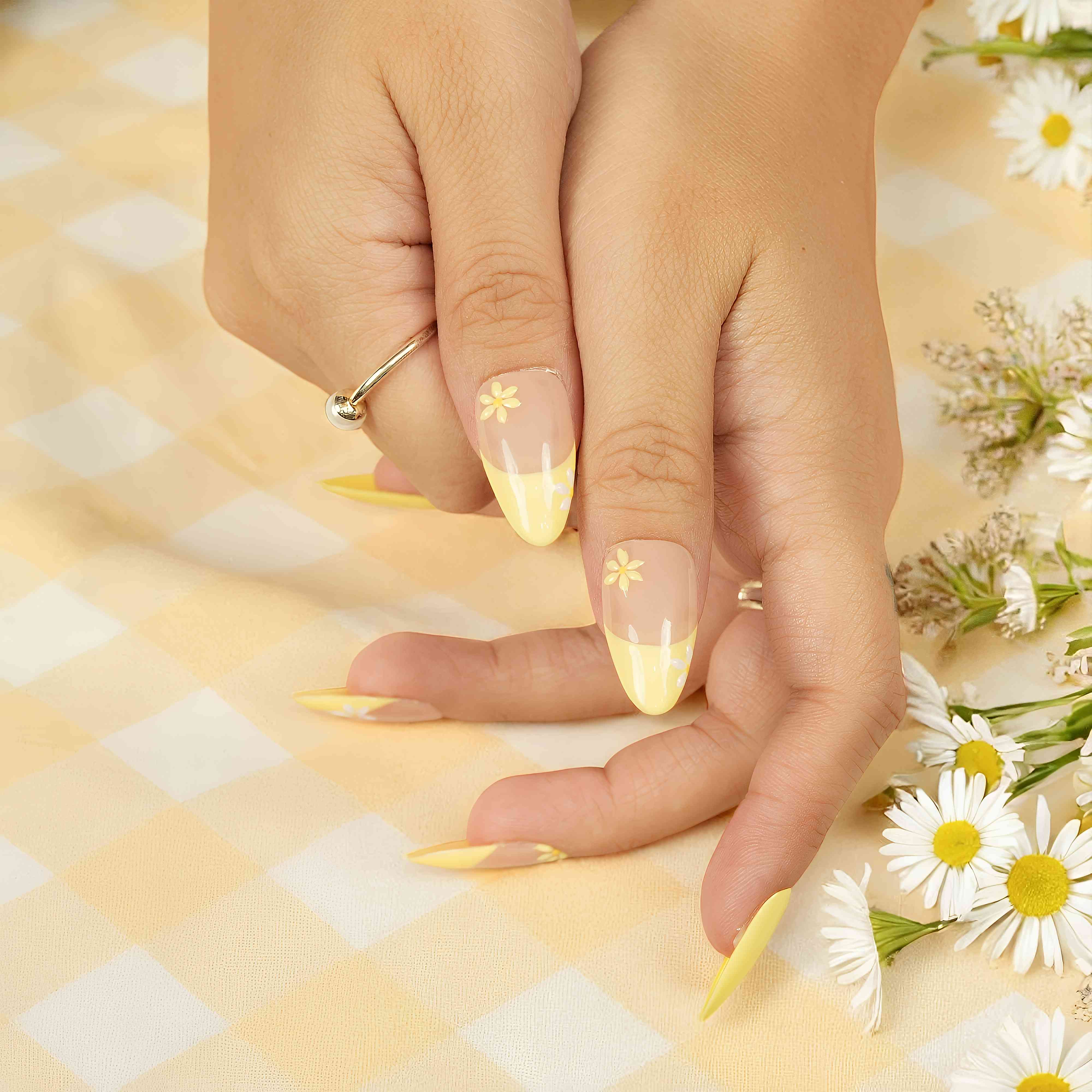 Natural press on nails with yellow daisy tips for fresh, casual looks.