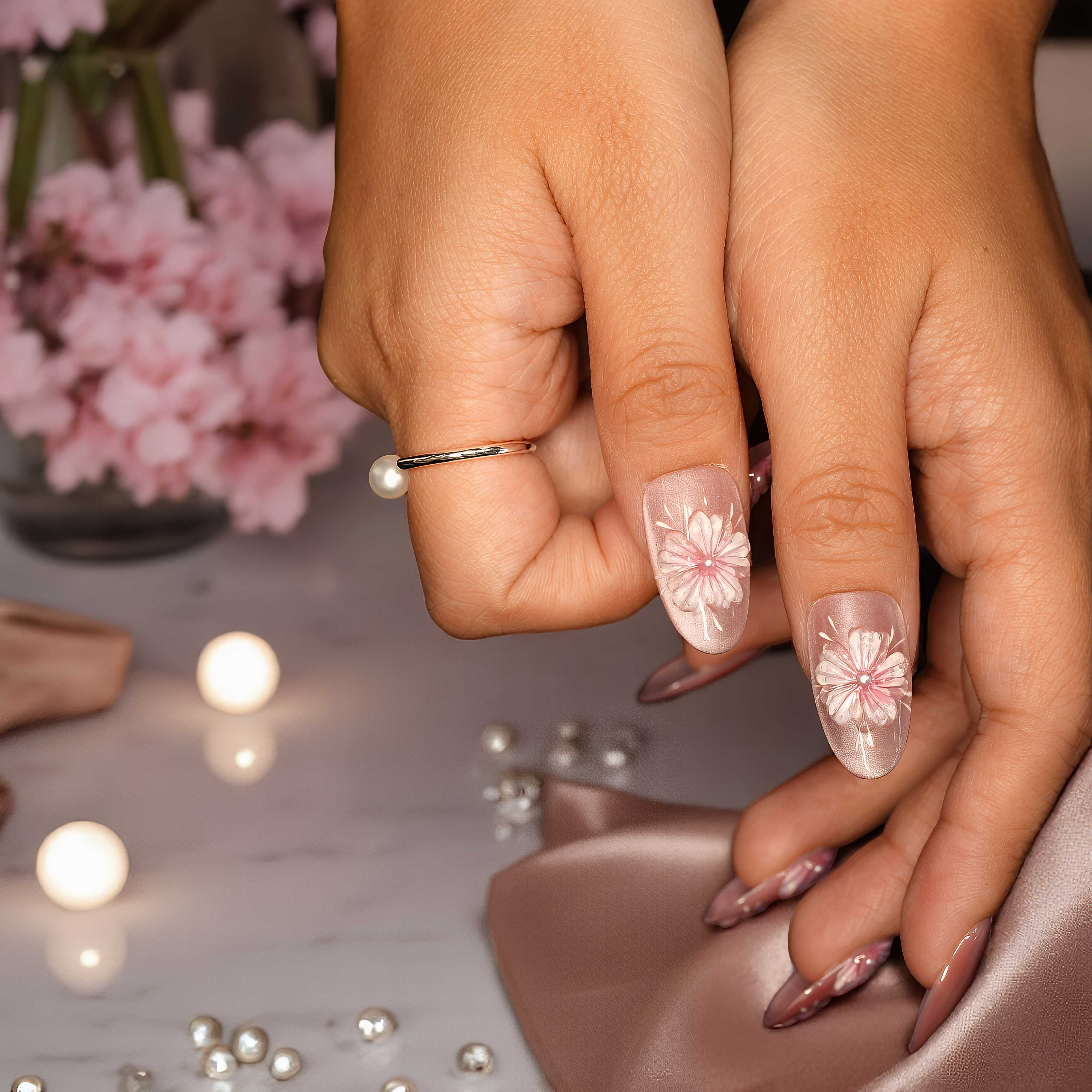 Floral stick-on nails in nude pink shades with delicate detailing and pearl finishes.