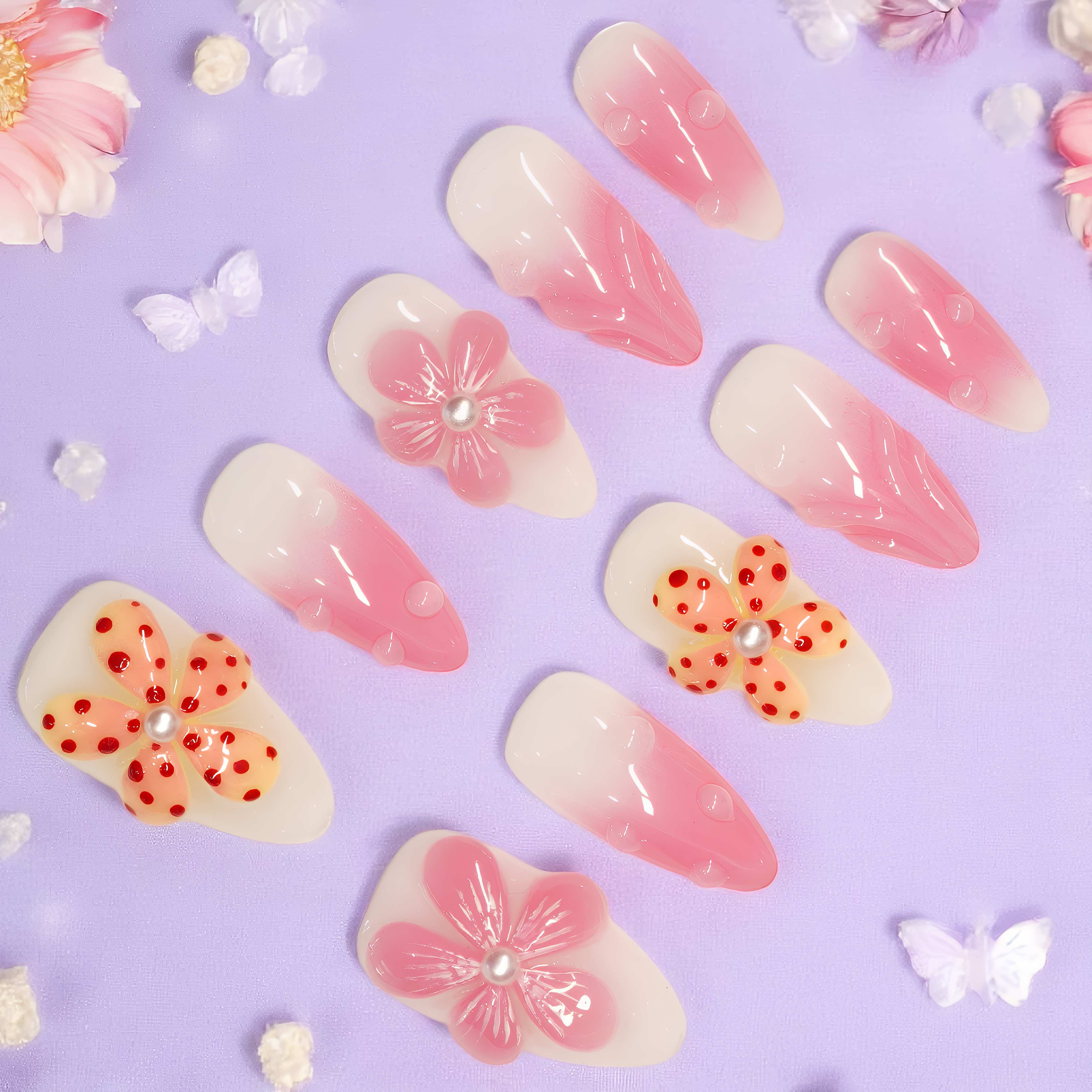 Petal Pop press on nails laid flat on lavender background, featuring pink floral 3D designs and glossy gradient tips