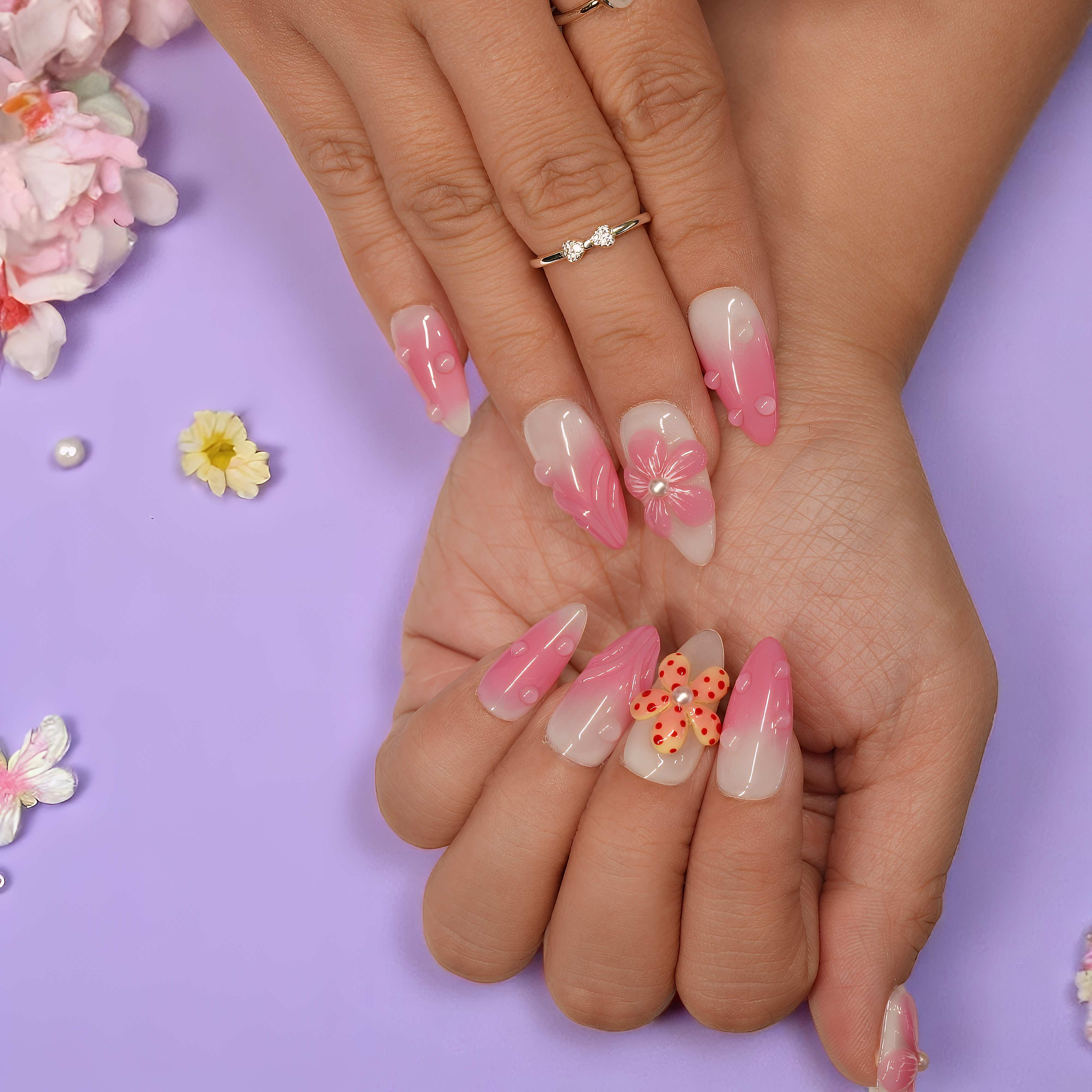 Full hand display of Petal Pop floral press on nails featuring sculpted 3D pink petals and soft almond tips.