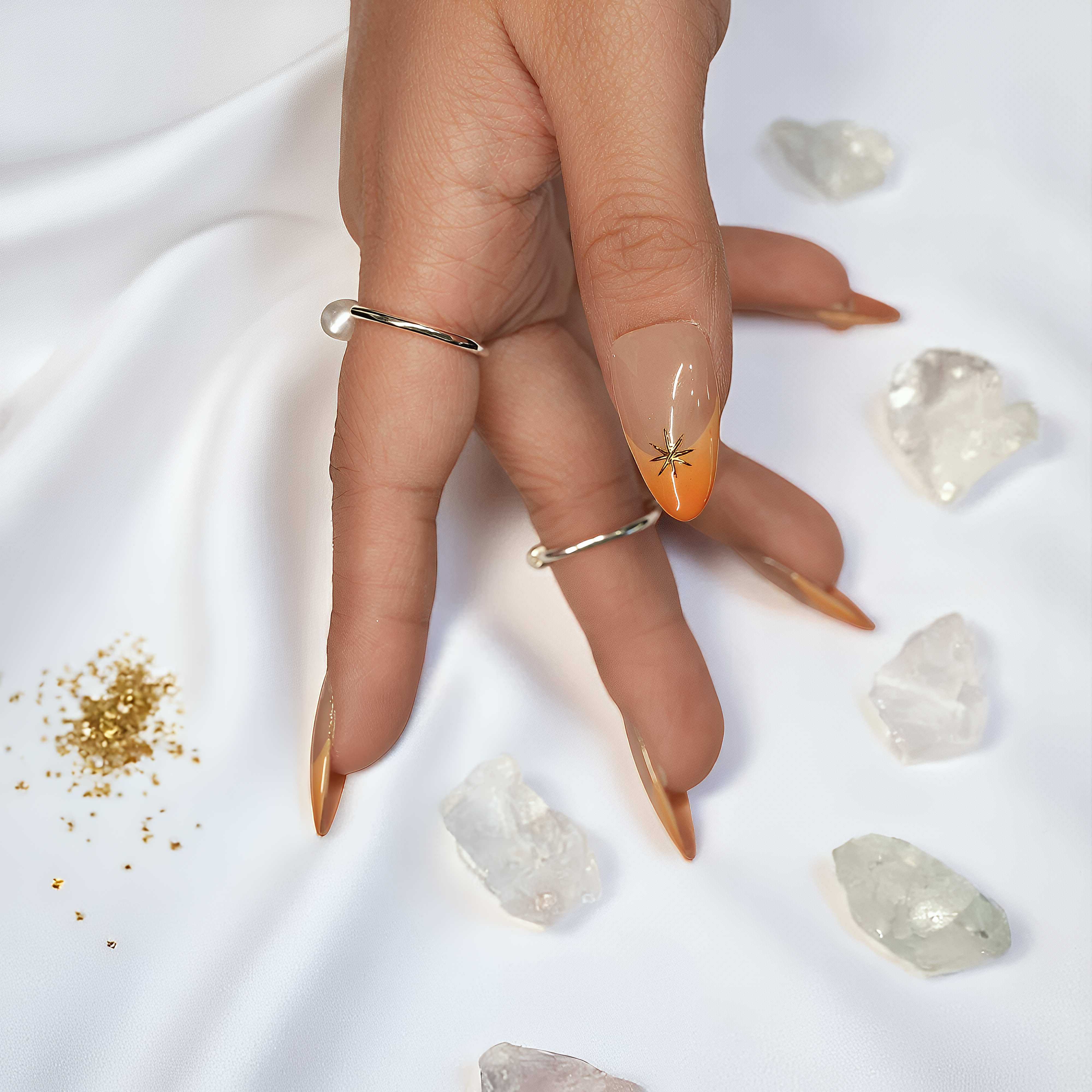Thumb nail detailed with orange French tip and fine gold star accent from the Sunset Nova set