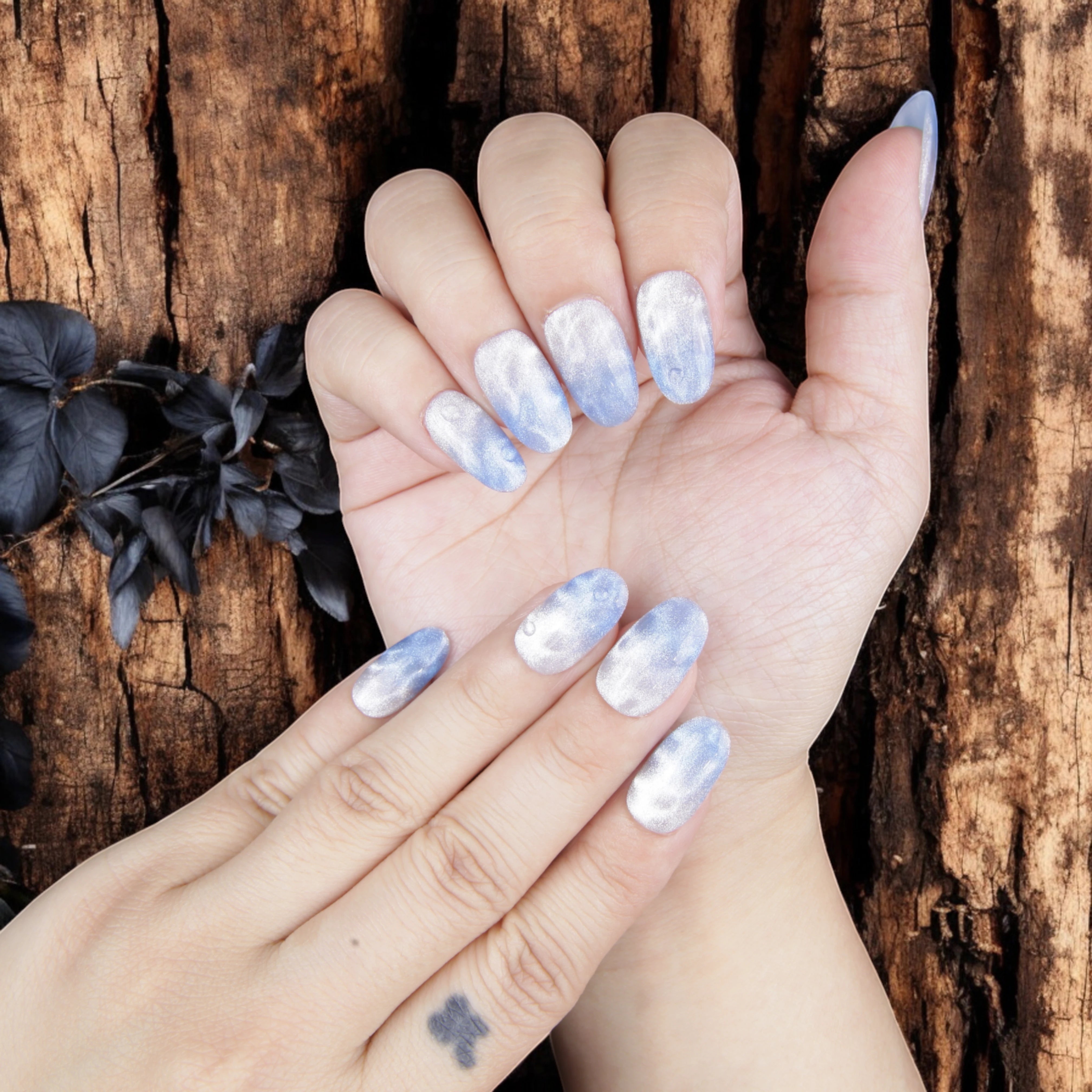 Close-up of shimmering blue glue on nails with a soft ocean mist effect, perfect for mermaid-inspired styles