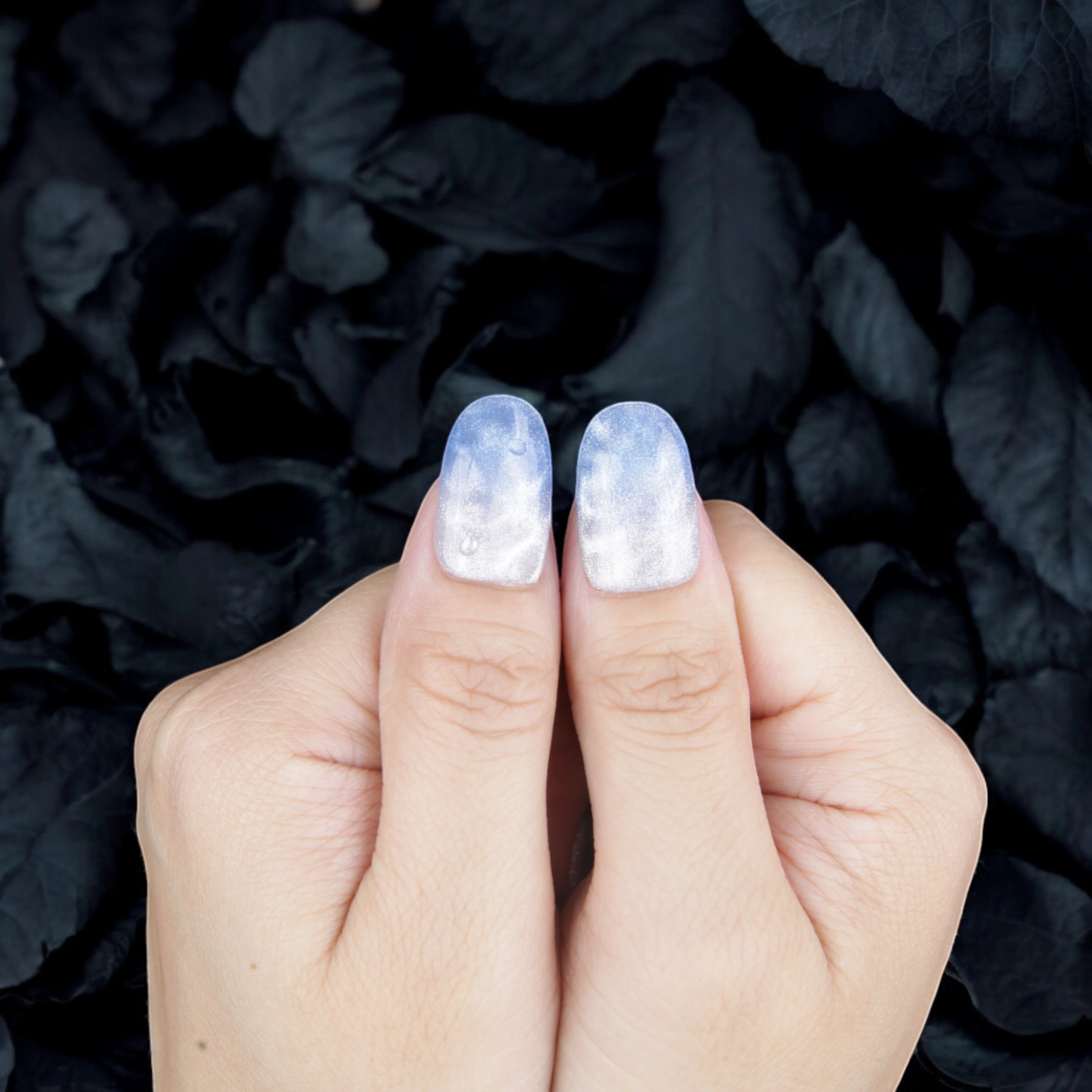 Blue water-effect stick on nails with a glossy finish, styled for a modern summer-ready look