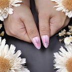 Light pink press on nails with silver ribbon bow accents and gems on thumbs, styled with white daisies – reusable handmade nails Australia