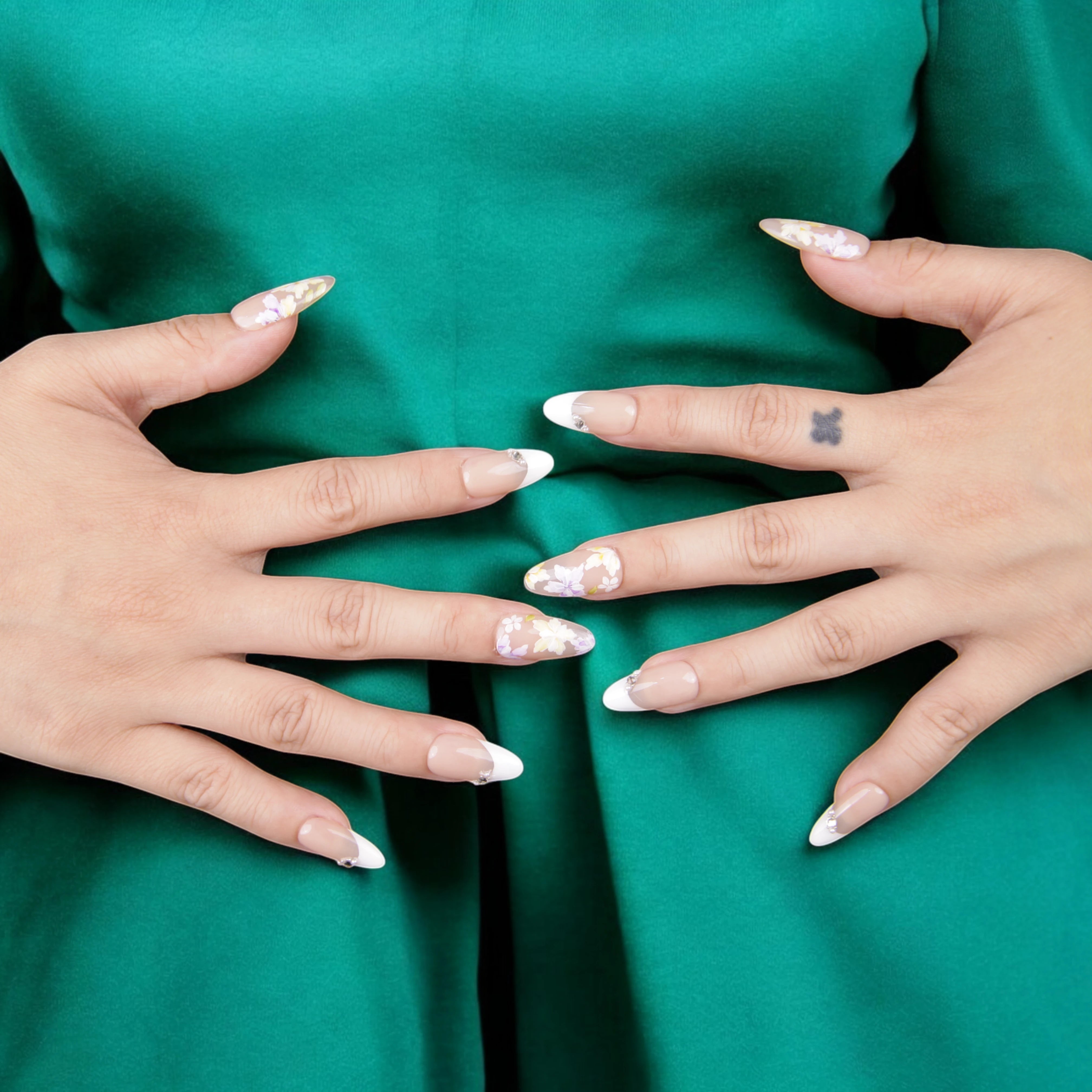 Graceful hand pose featuring floral press on nails with French tips, perfect for a chic, classic, and nature-inspired nail design.