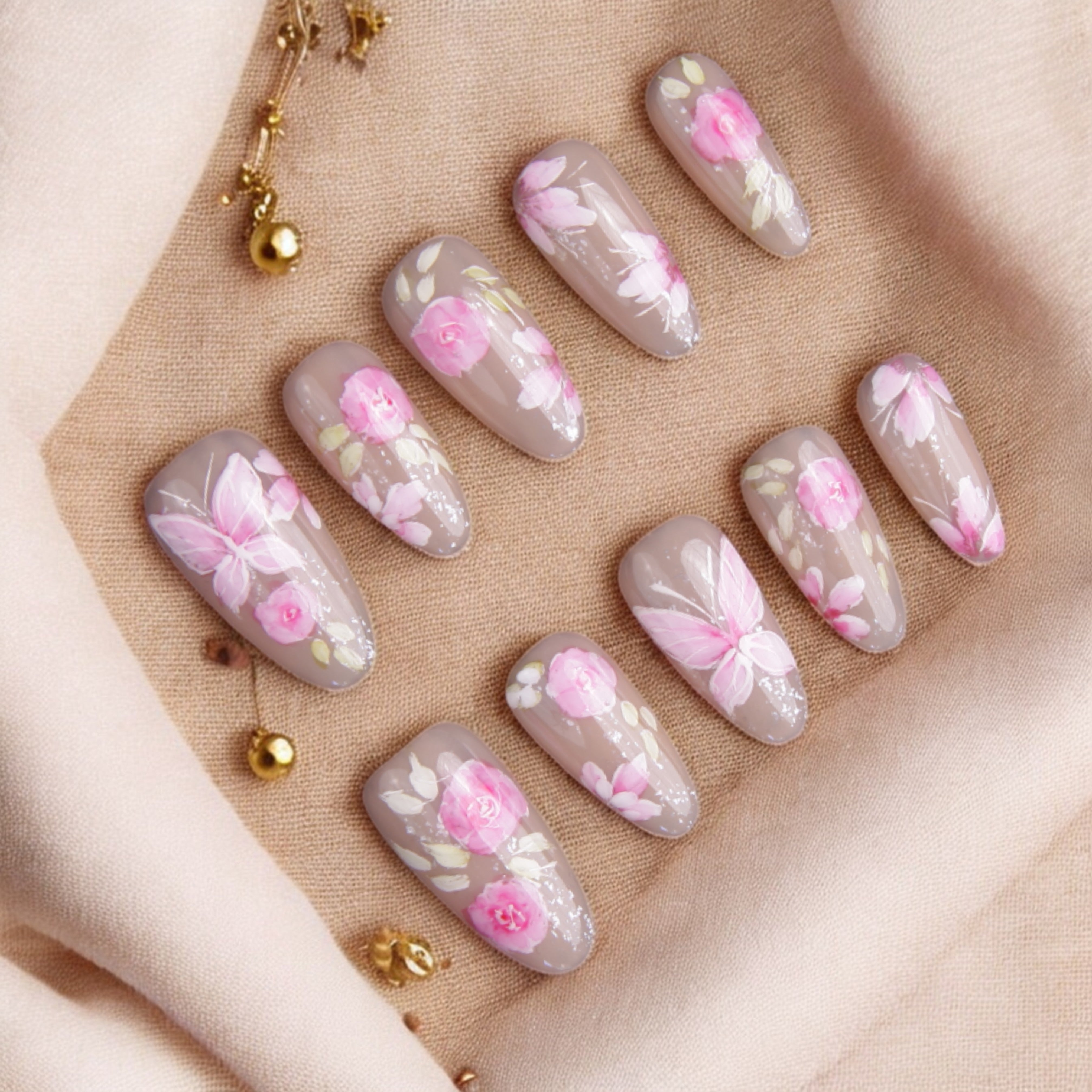 Elegant floral artificial nails with a soft beige base and pink flower details, perfect for an Australian nail salon look.