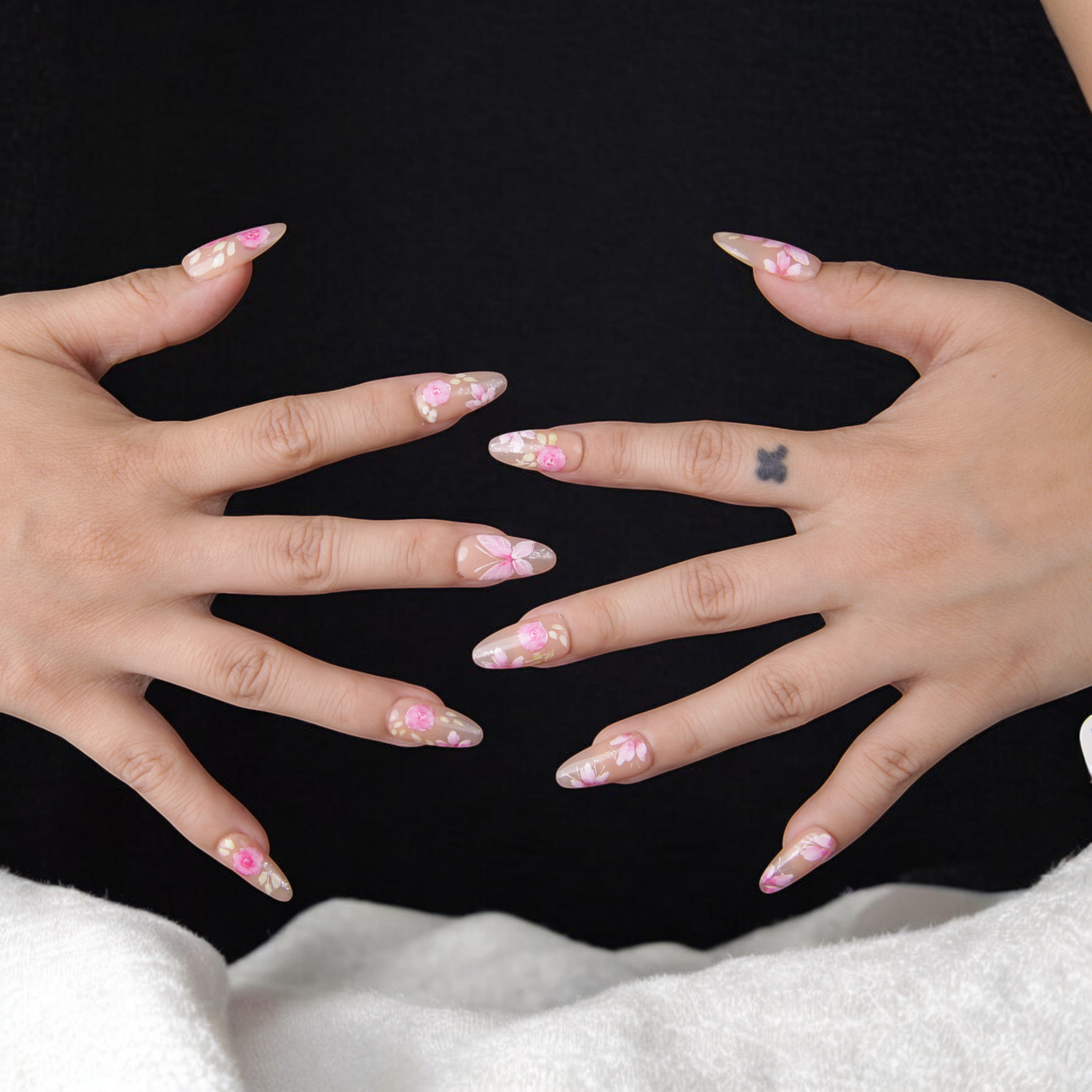 Handmade floral false nails featuring a neutral-toned base and delicate flower designs for a classy and sophisticated manicure.