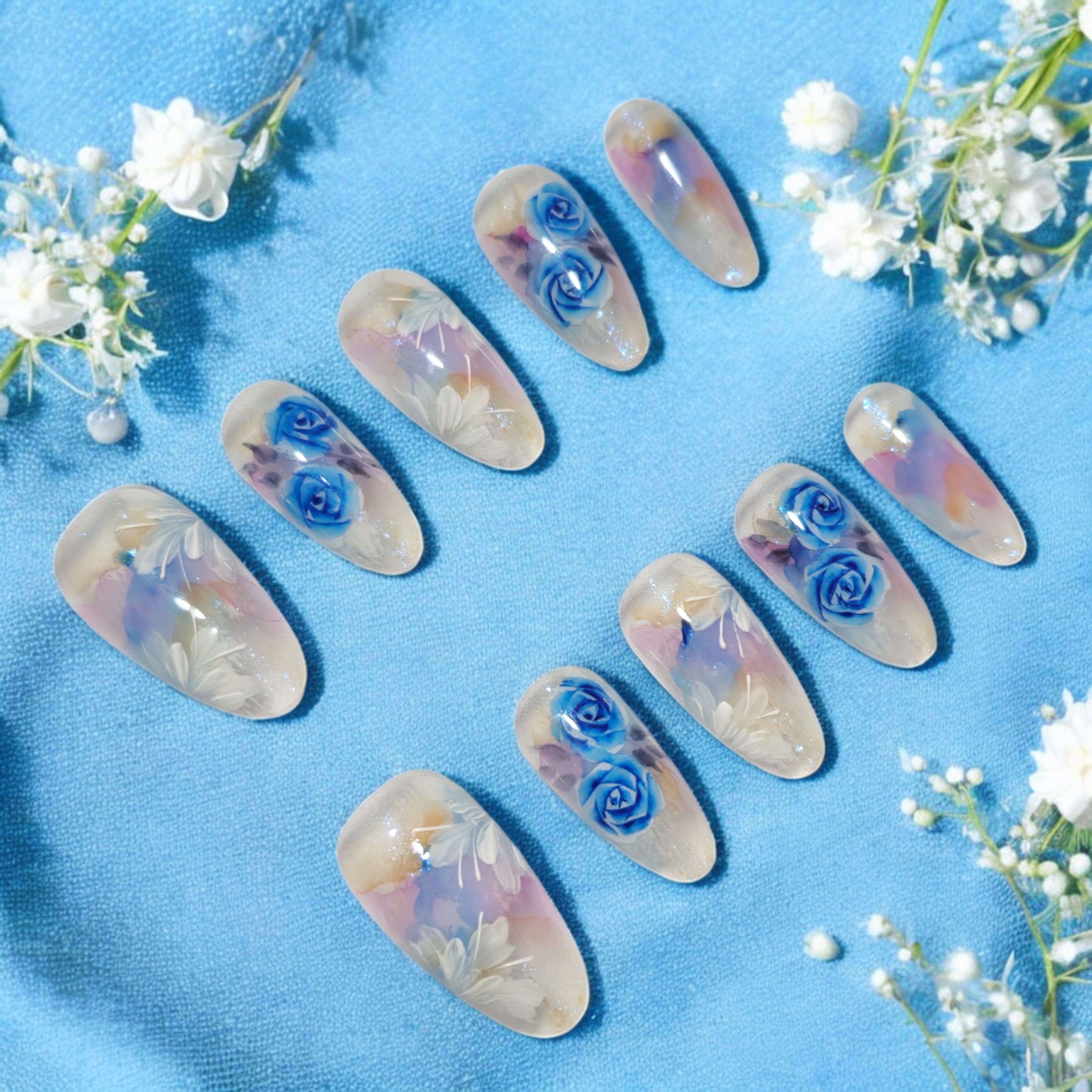 Blue rose-themed long artificial nails with a dreamy watercolor effect. Stick-on nails with salon-quality finish, ideal for instant glamour at home
