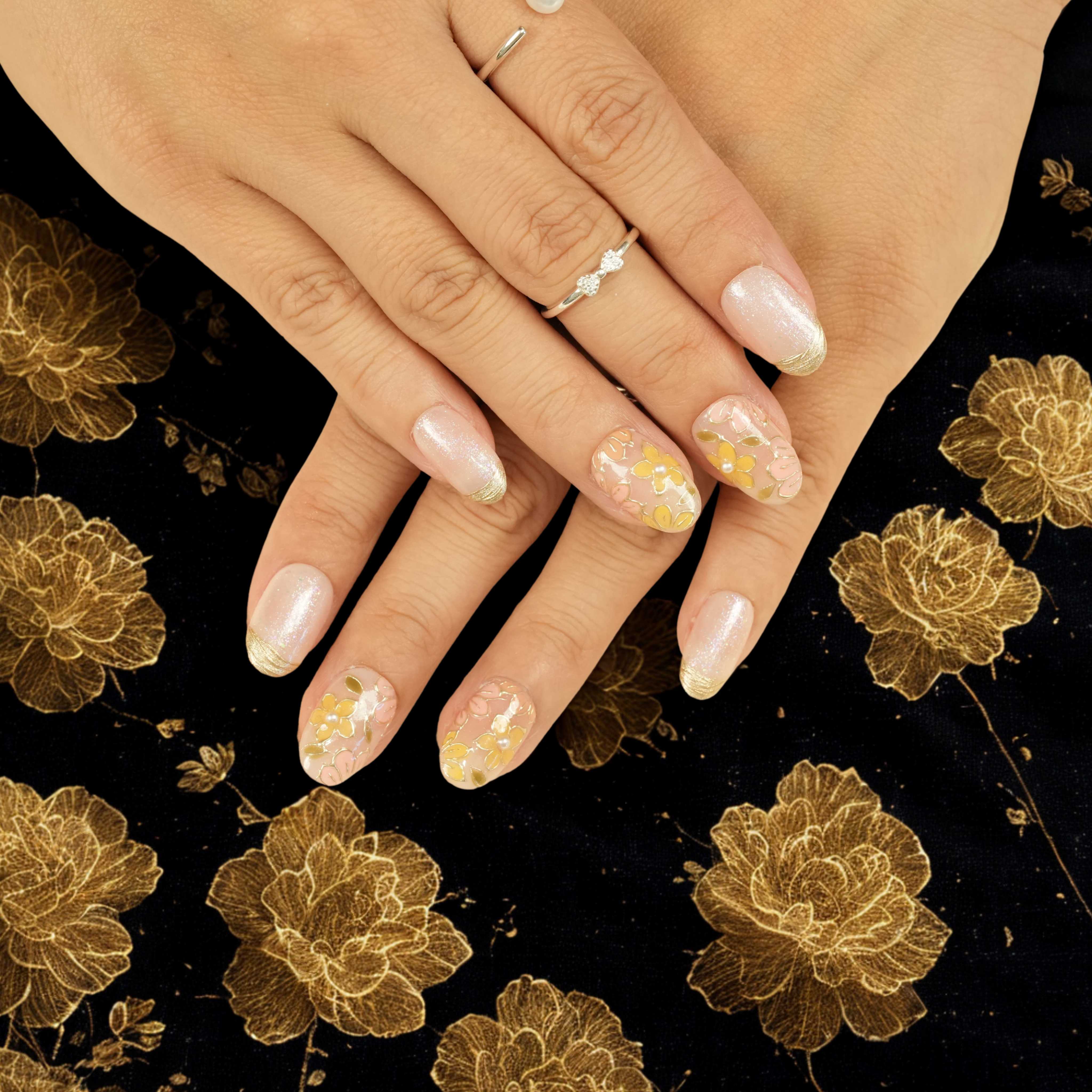 Artificial nails Australia with yellow flower designs, gold metallic accents, and natural almond shapes, perfect for weddings and events