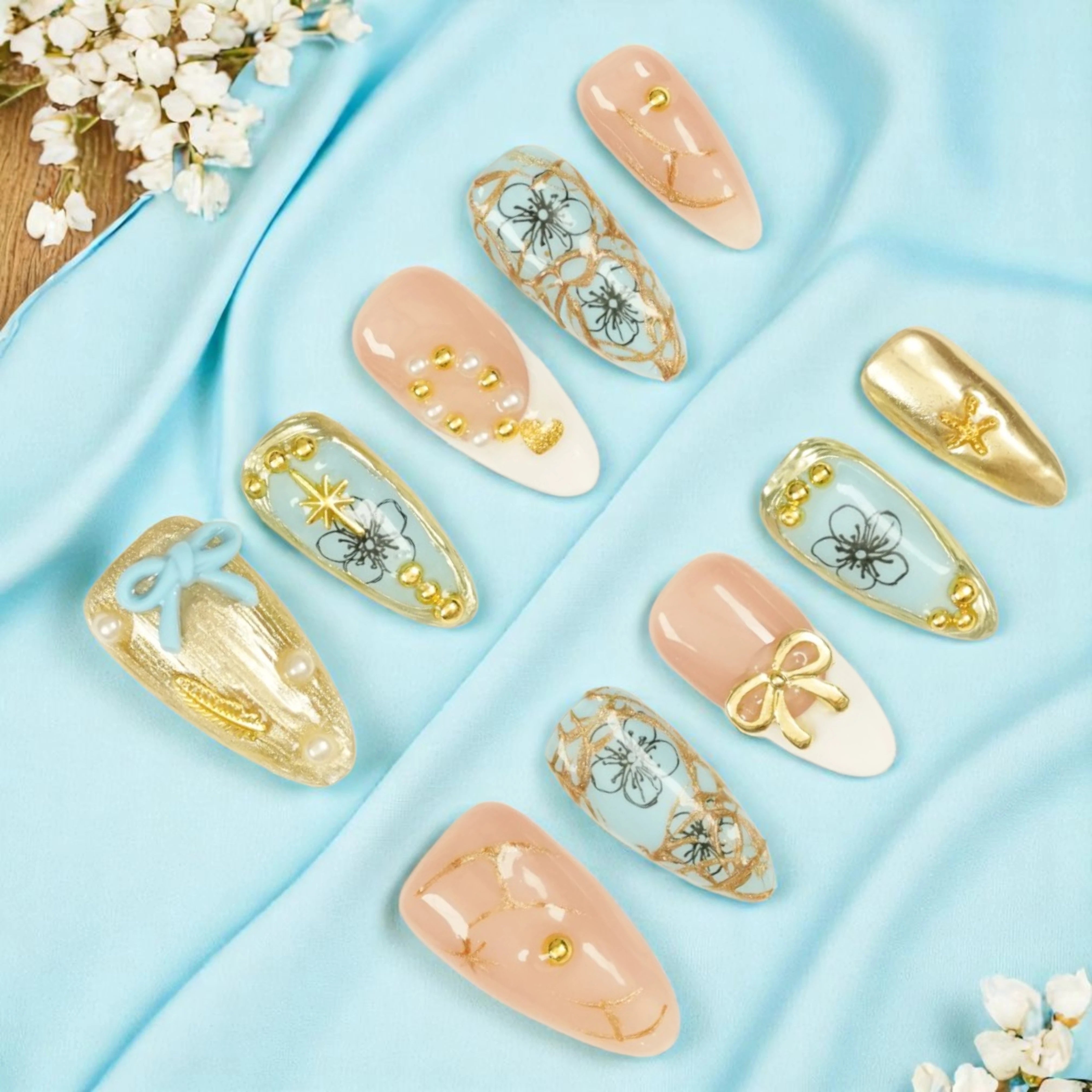 Handmade blue and gold bow press on nails with floral and pearl details, elegant and luxury style