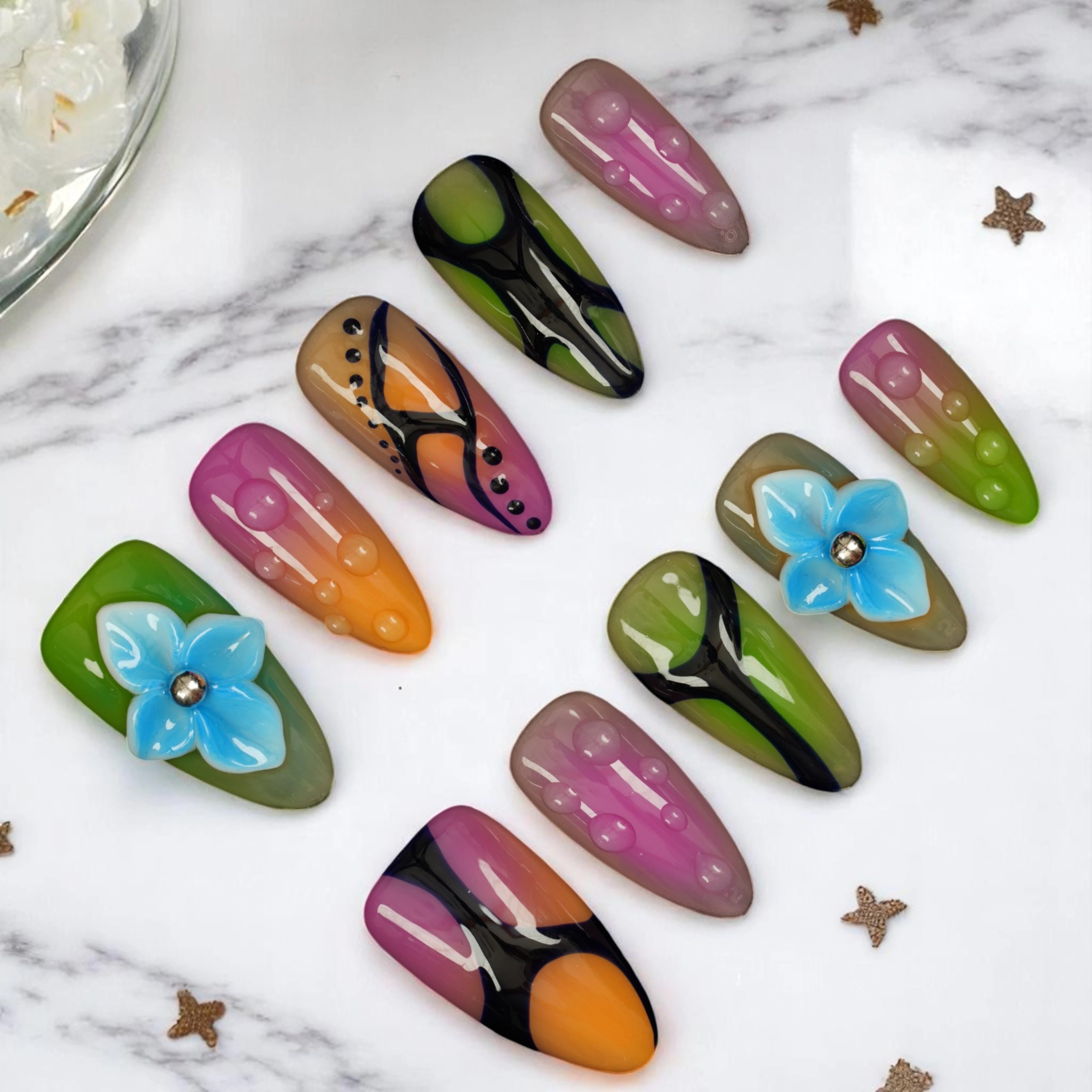 top view reusable press on nails Australia with multicolour abstract design and floral accent