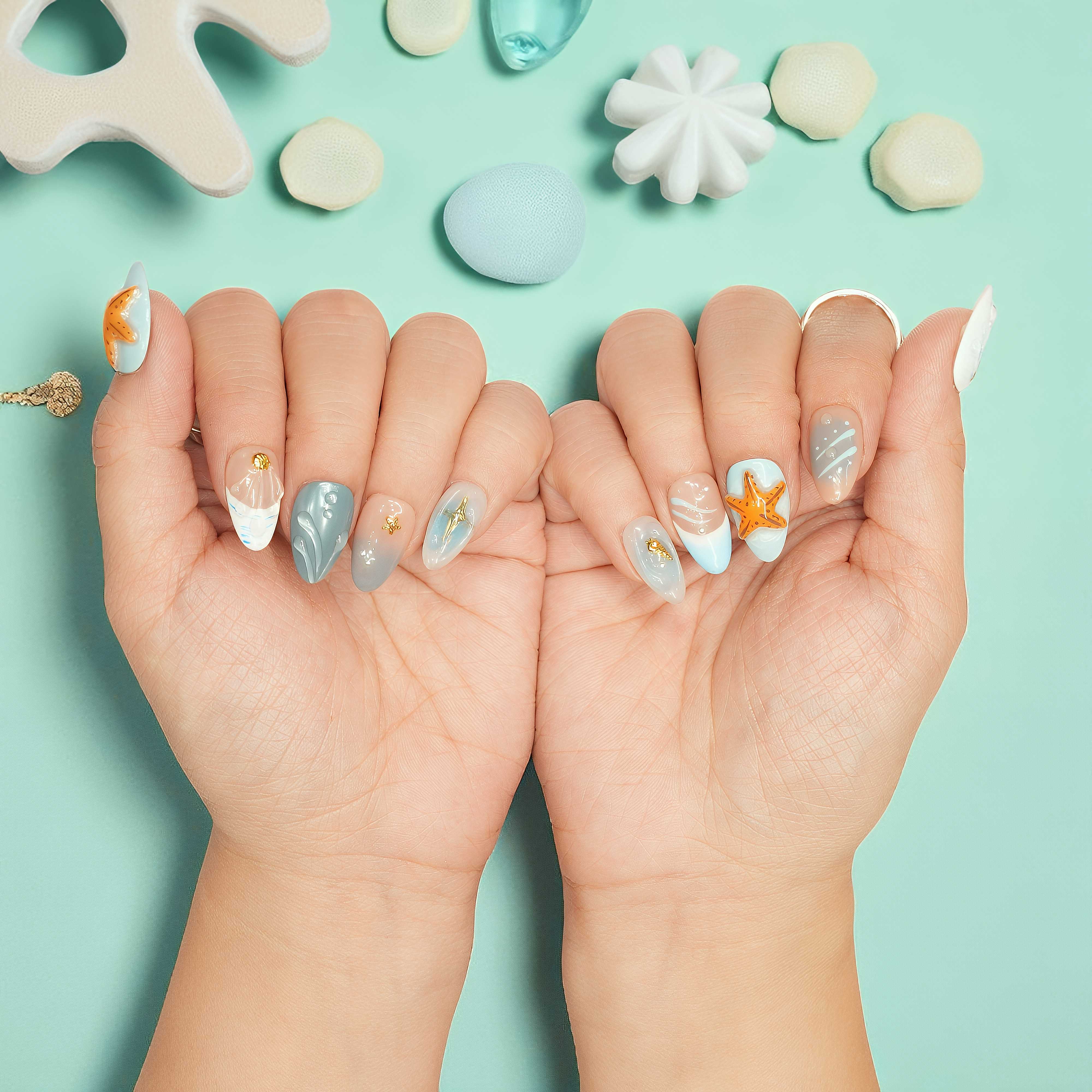 Ocean-inspired press on nails with sculpted orange starfish and sandy blue tones – coastal summer vibes.