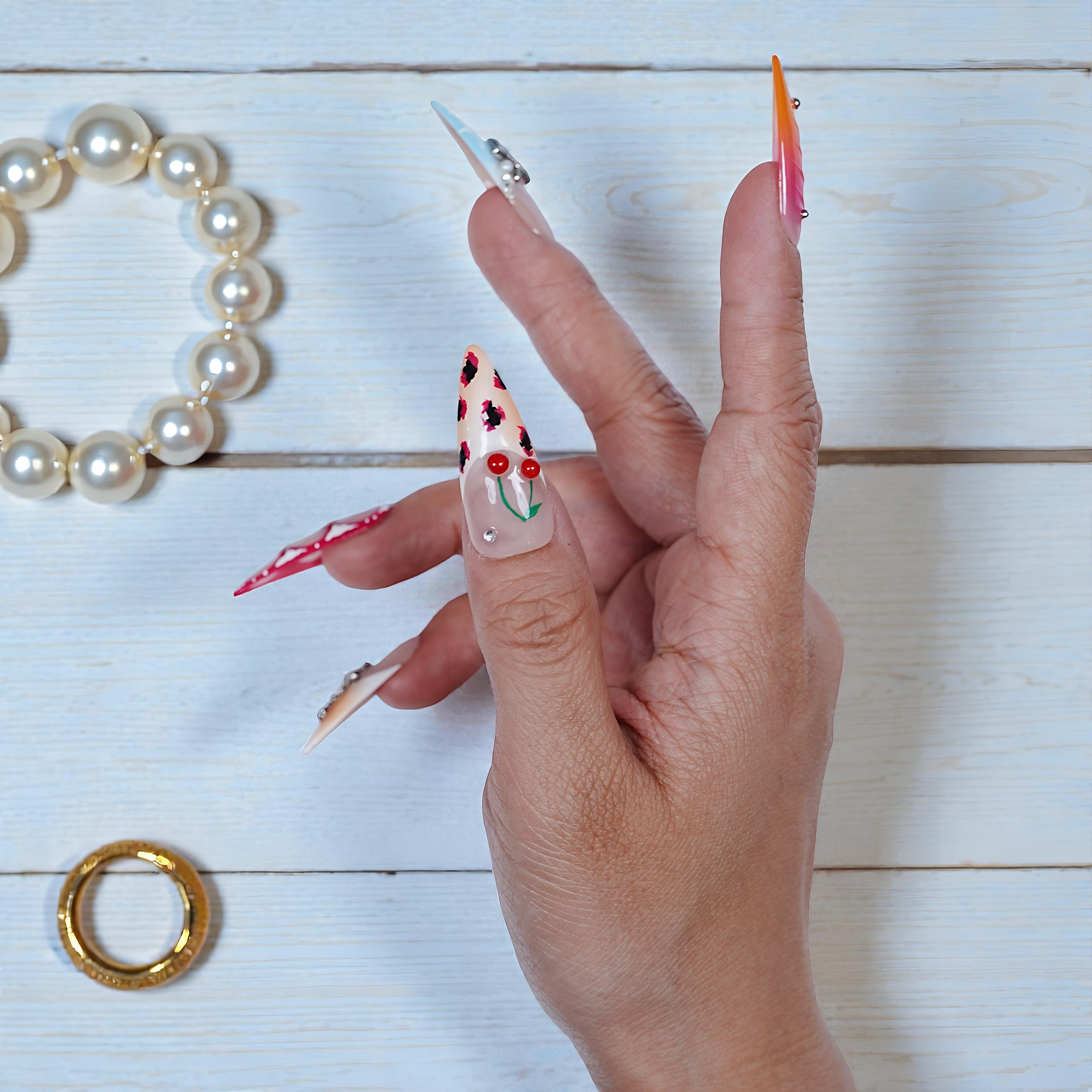 Close-up of nail with red-yellow ombre and chrome tip on stiletto shape