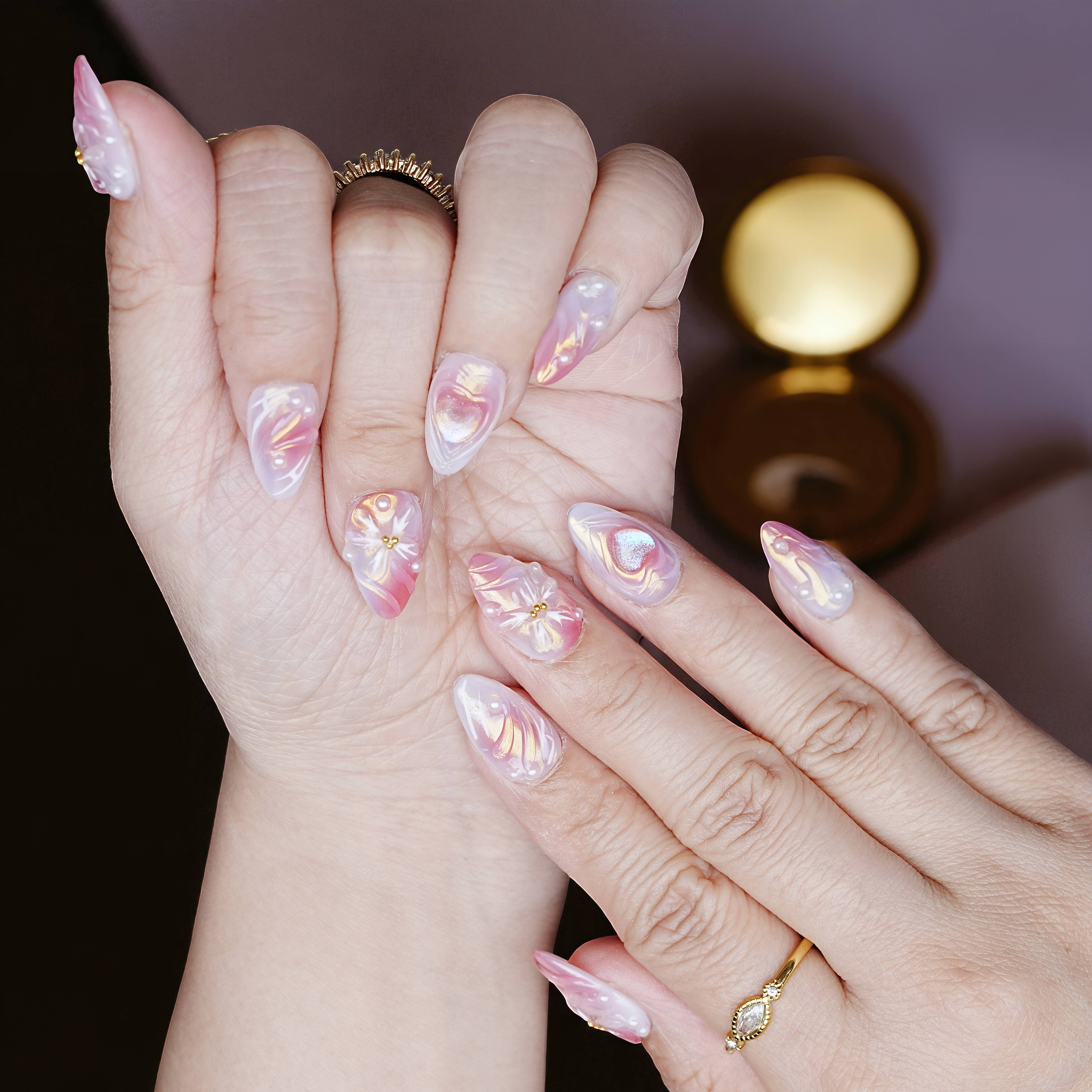 Fingertip display of long almond press on nails with iridescent sheen and pastel chrome layering.