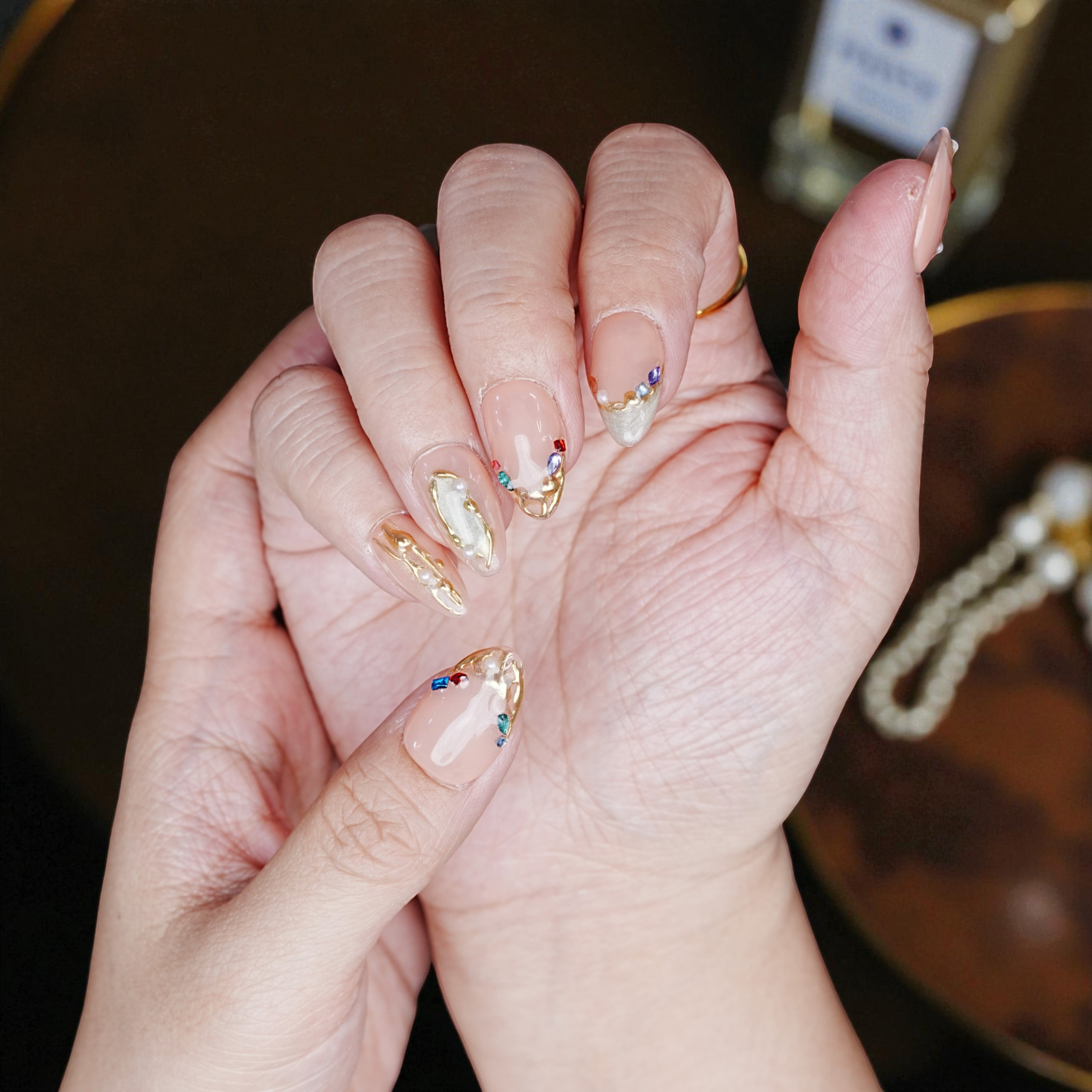Side view of blush chrome floral nails with reflective shine