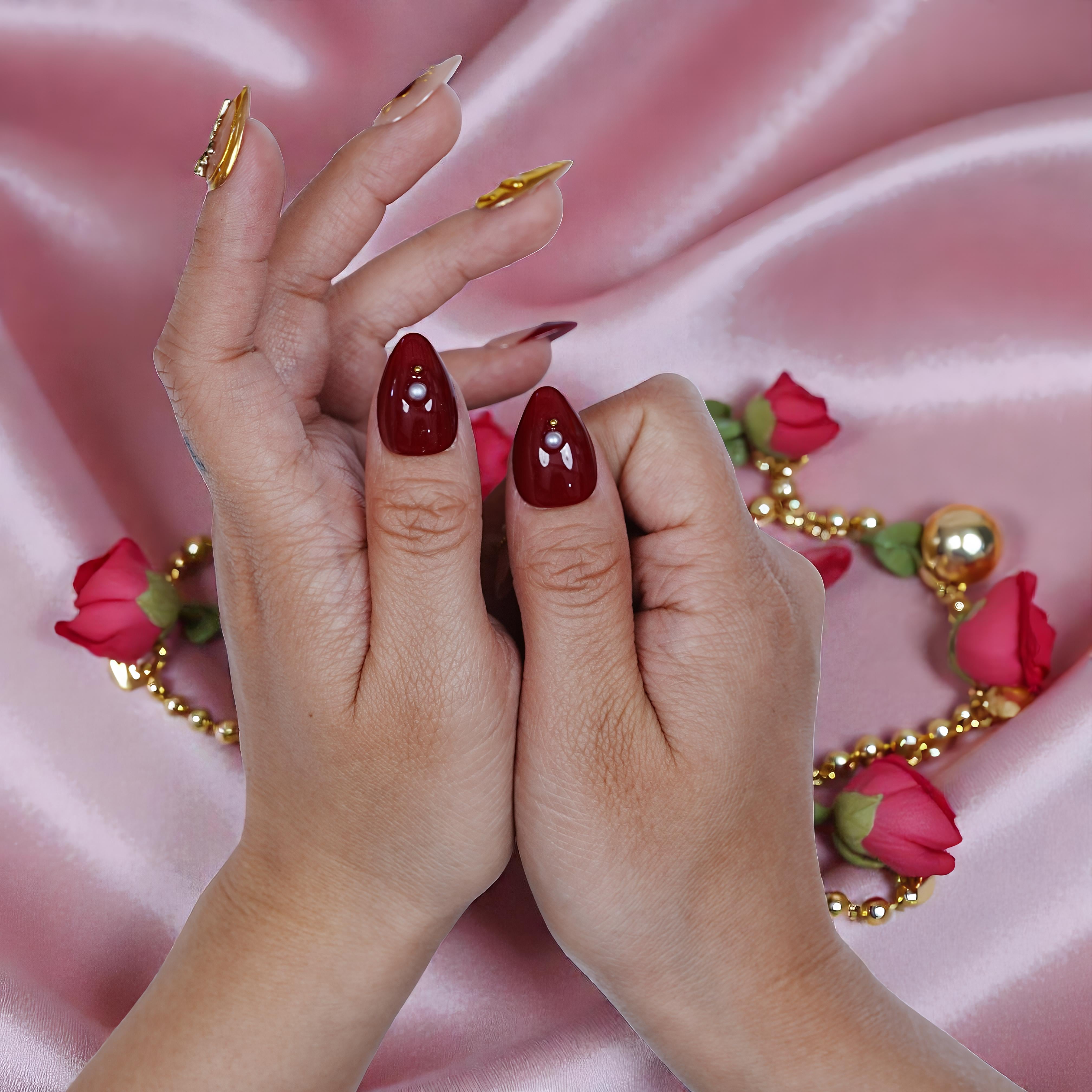 Handmade press on nails in glossy red with pearl accents on pink silk, roses and gold beads