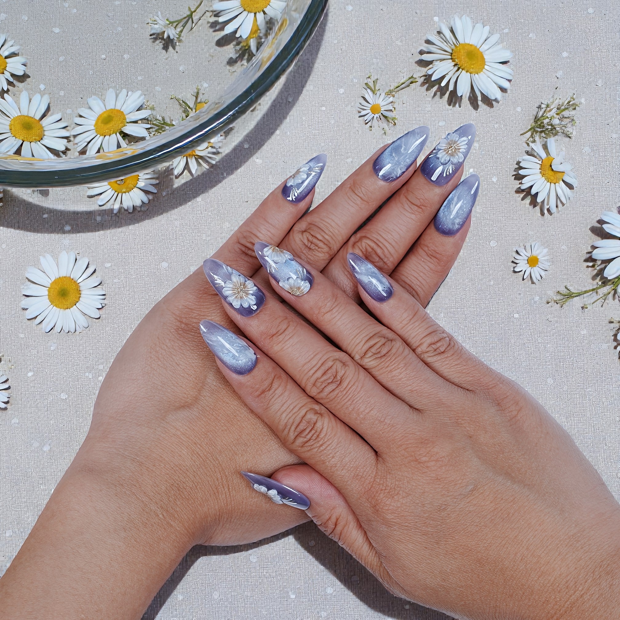 Hand with lilac daisy press on nails, handmade, surrounded by daisies, Dress For Nails Australia