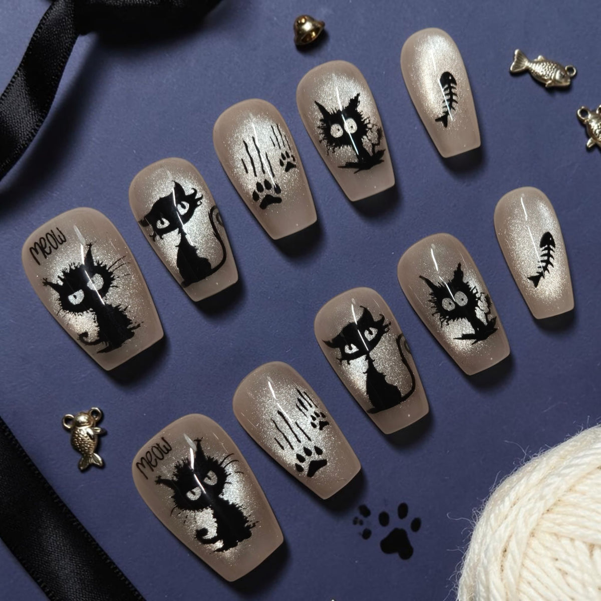 Scaredy Cat cat lover press on nails with scruffy black ink cats, MEOW lettering, claw scratches and fish bones on champagne coffin nails