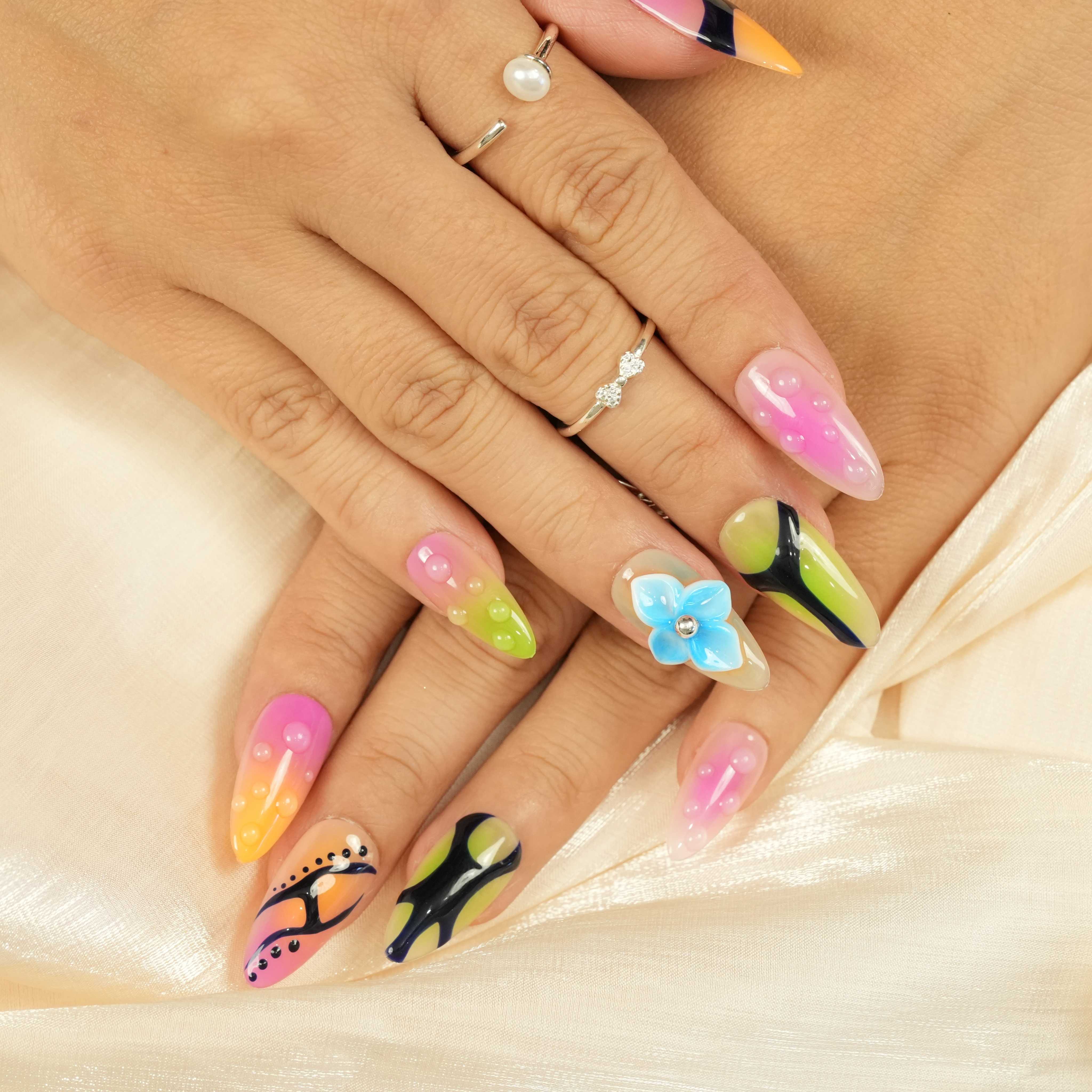 bold handmade press on nails with neon pink, green, and orange abstract designs