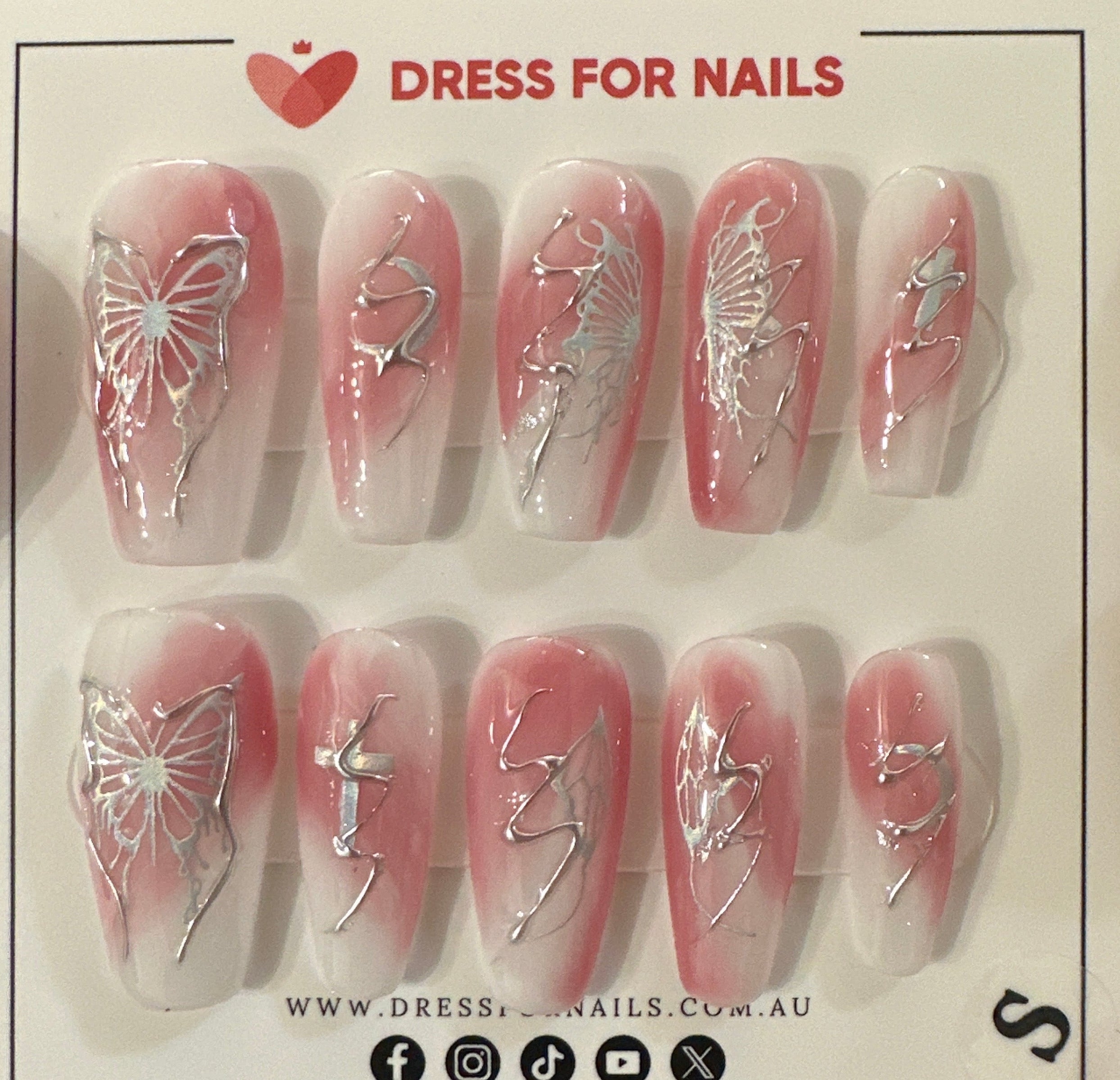 Set of false nails in a packaging box held by a person.