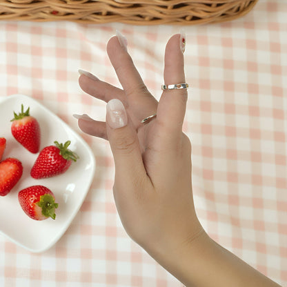 Press on nails with strawberry and floral art laid out in a 10-piece almond shape set