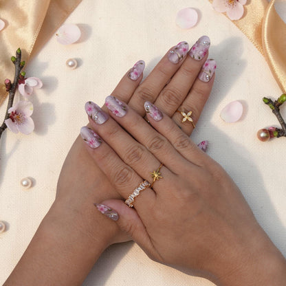 DSC00012 hands wearing sakura press on nails with pink blossoms and gold accents