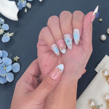 DSC00026 hand wearing blueberry press on nails with a 3D blue flower, gingham bow and pearls