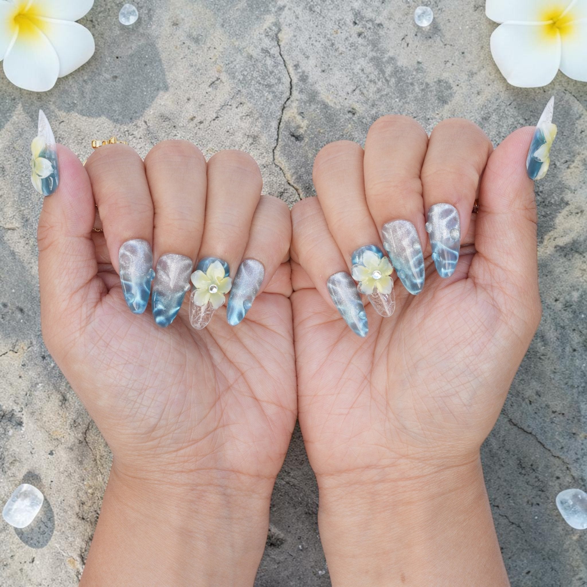 DSC00041 pair of hands showing blue frangipani press on nails from the front