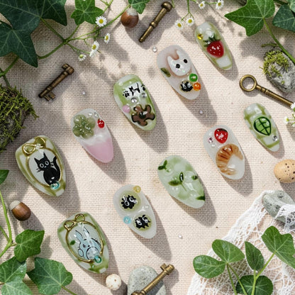 DSC00047 matcha press on nails full set in green and cream with cute forest characters, 3D strawberries and a croissant laid flat