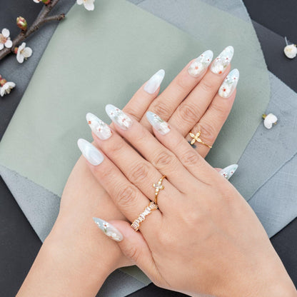DSC00054 hands wearing white floral press on nails with painted blossoms and gold rings