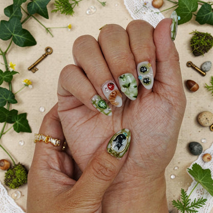 DSC00055 hand wearing matcha green press on nails with a four leaf clover and a 3D strawberry